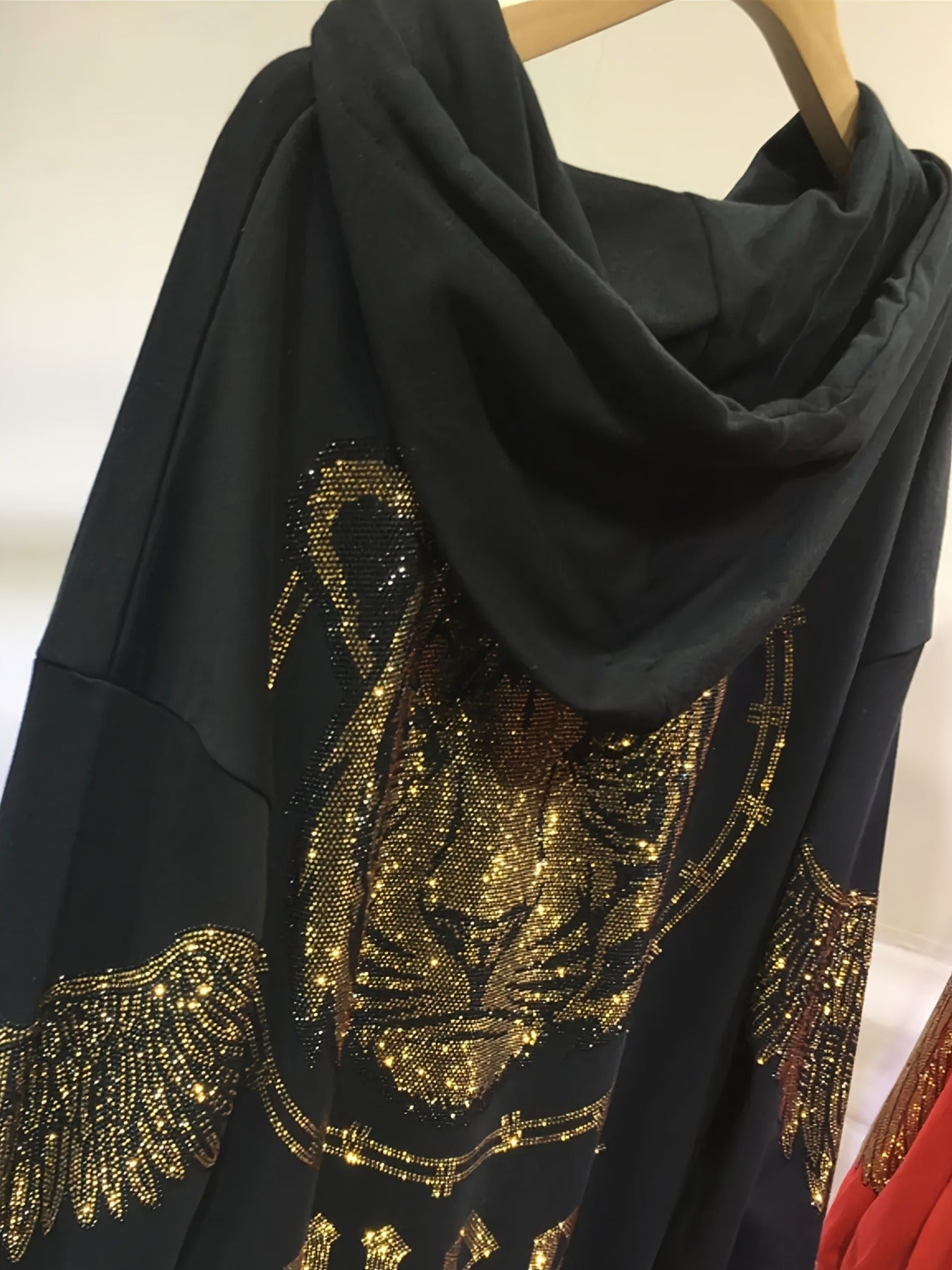 Katta o'lchamdagi ayollar uchun kapüşonli ko'ylak, porlaydigan yo'lbars rhinestones bilan, 100% polyester to'qima matodan tayyorlangan. U uzun yenglar, kapüşon, geometrik naqsh, keng cho'ntak bilan jihozlangan, bahor/kovak uchun mos.