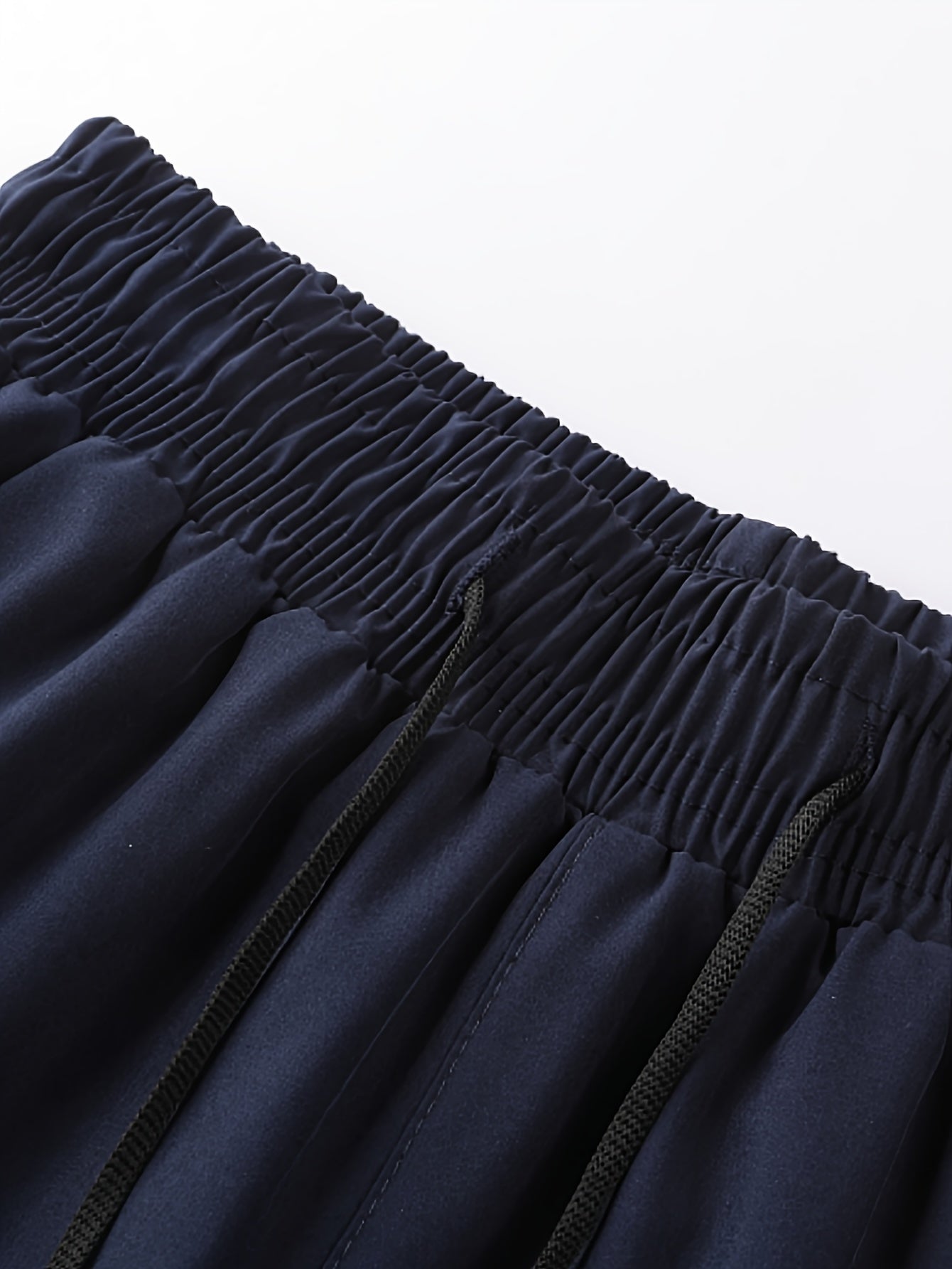 Erkaklar uchun qora aksentli dengiz ko'k sport shortlari, tez quriydigan, nafas oladigan, tortish bilan elastik bel, polyester va spandeks aralashmasidan tayyorlangan.