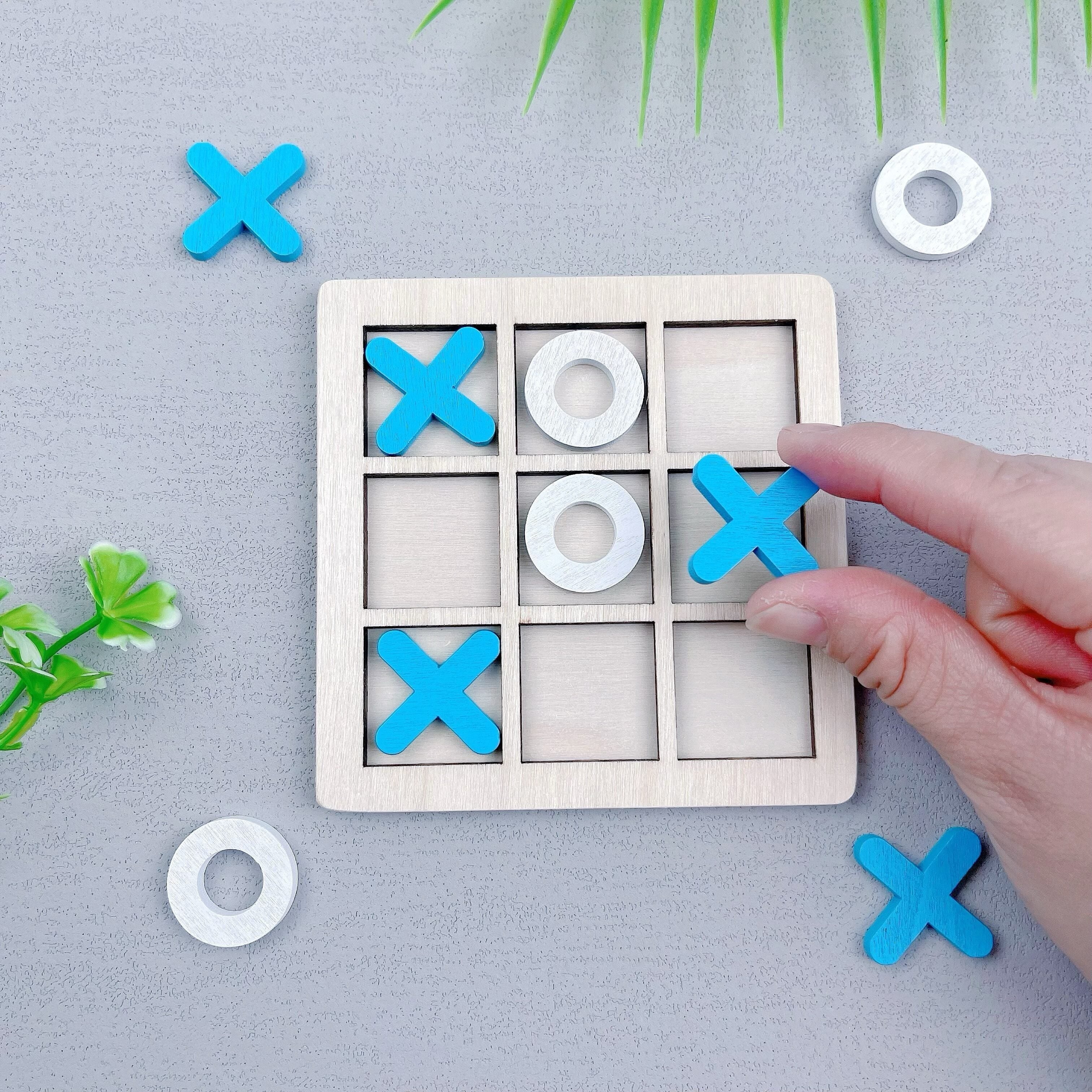 Ta'lim beruvchi, ikki o'yinchi uchun Tic Tac Toe o'yini, turli rangdagi yog'och XO qismlari bilan.