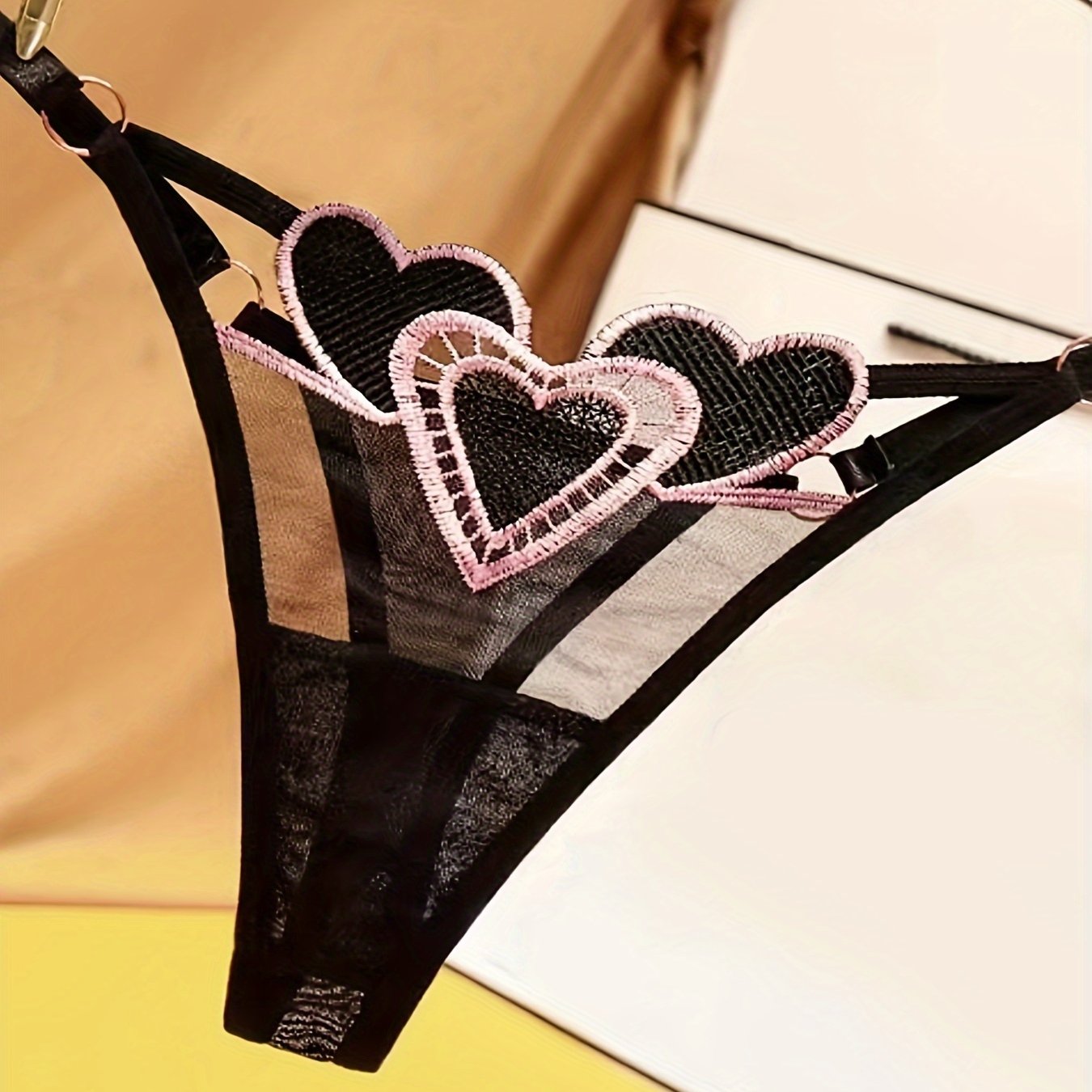 Ayollar uchun yurak naqshli thong ichki kiyim, moslashtiriladigan kattalashtirilgan o'lchamda, nafas oladigan to'r va jozibali to'qima bilan. Past bel, tungi klub uslubi, polyester materialda, S/M/L o'lchamlarida mavjud.