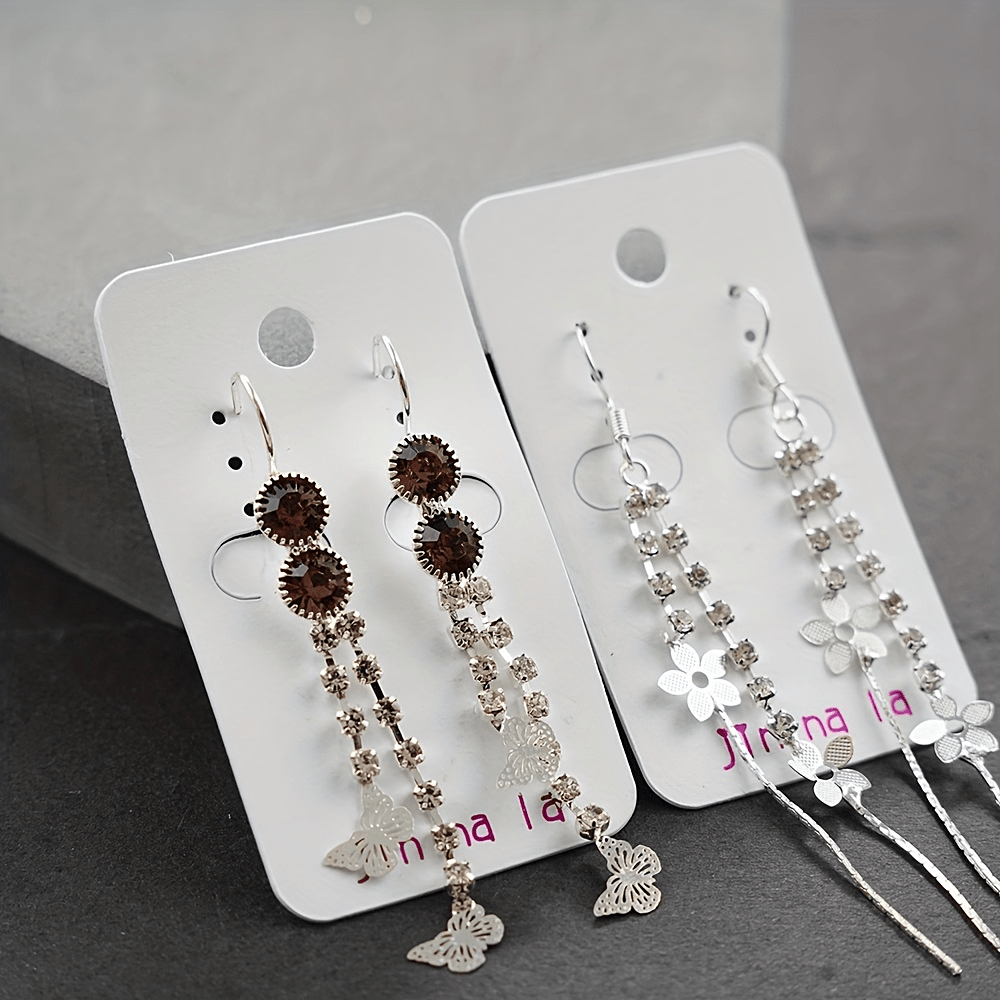 20 juft osma sirg'alar to'plami, porloq rhinestone'lar bilan bezatilgan, nafis va klassik uslubga ega. Sink qotishmasidan tayyorlangan, bu zamonaviy aksessuarlar har qanday kiyimga nafislik qo'shish uchun mukammaldir. Moda ixlosmand ayollar uchun ideal.