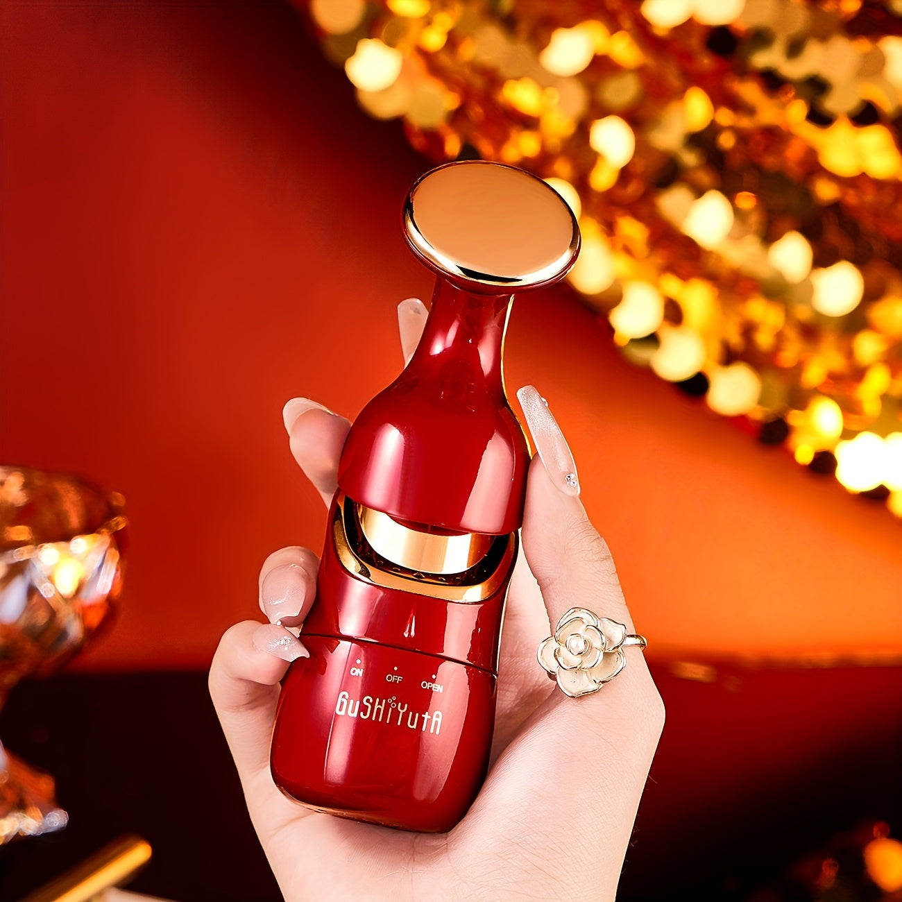 Qizil va oltin ranglarda bo'lgan, dam olish, teri parvarishi va mushaklarni rag'batlantirish uchun ko'p funksiyali yuz, ko'z va bo'yin massaj qiluvchi.