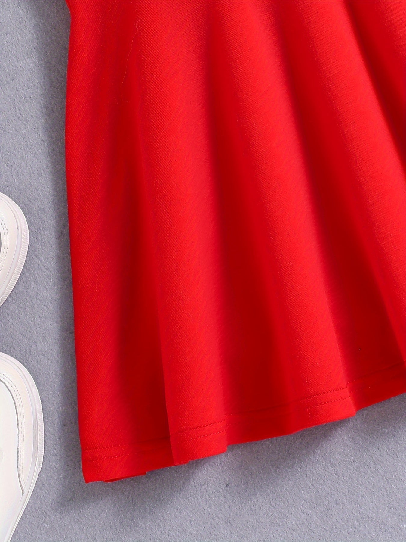 Qizlar uchun qizil tennis va sport libosi, nafas oladigan, teri so'radigan polyesterdan tayyorlangan, cho'ziluvchan va yengsiz dizayni bilan sport va tasodifiy kiyimlar uchun qora yozuvlar bilan sportiy nafislikni taqdim etadi.