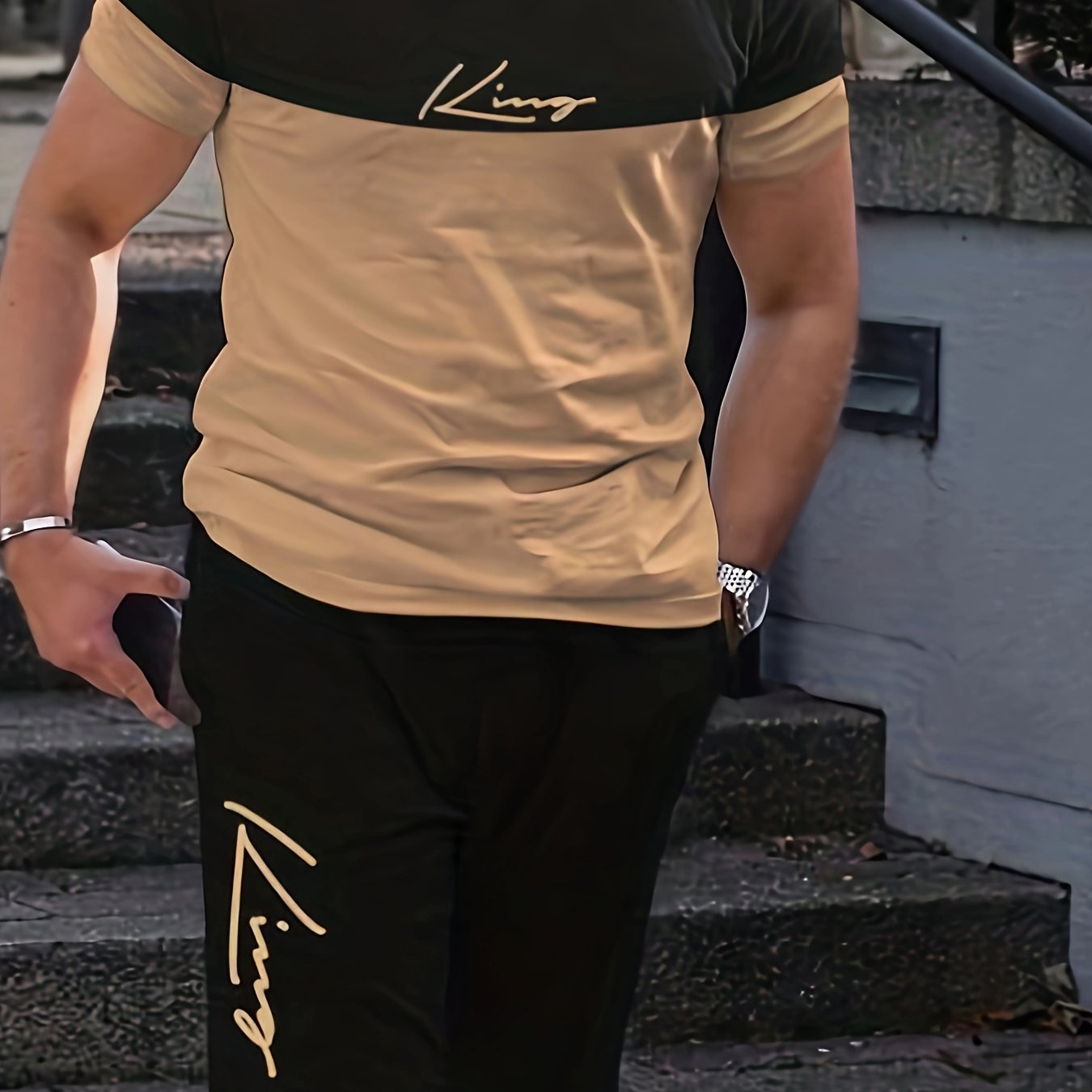 Katta o'lchamdagi erkaklar uchun "King" grafik printli ikki qismli futbolka va shortlar to'plami, mashg'ulotlar va ochiq havoda faoliyatlar uchun mukammal. Katta va baland erkaklar uchun zamonaviy ortiqcha o'lchamdagi sport kiyimi.