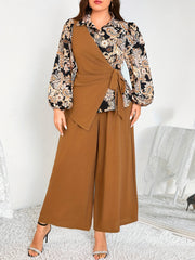 Katta o'lchamdagi ayollar uchun zamonaviy gullar bilan bezatilgan ikki qismli to'plam - bog'ichli bel detali va keng oyoqli shimlar bilan asimmetrik uzun qo'lqopli bluzka, mashinada yuvish mumkin, polyesterdan tayyorlangan.