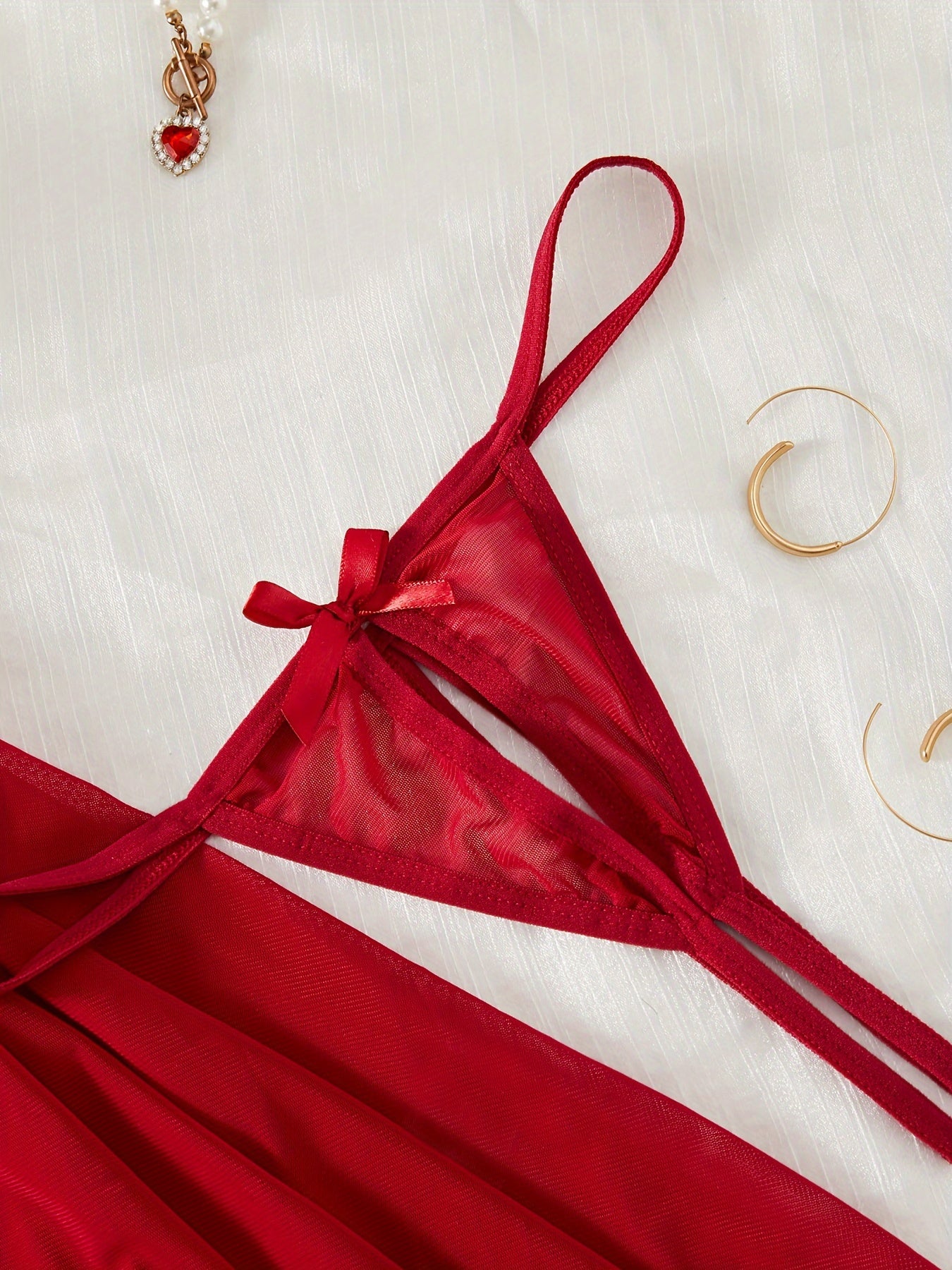 Ayollar uchun jozibali ichki kiyim to'plami, dantel slip ko'ylagi, thong va chokerdan iborat.