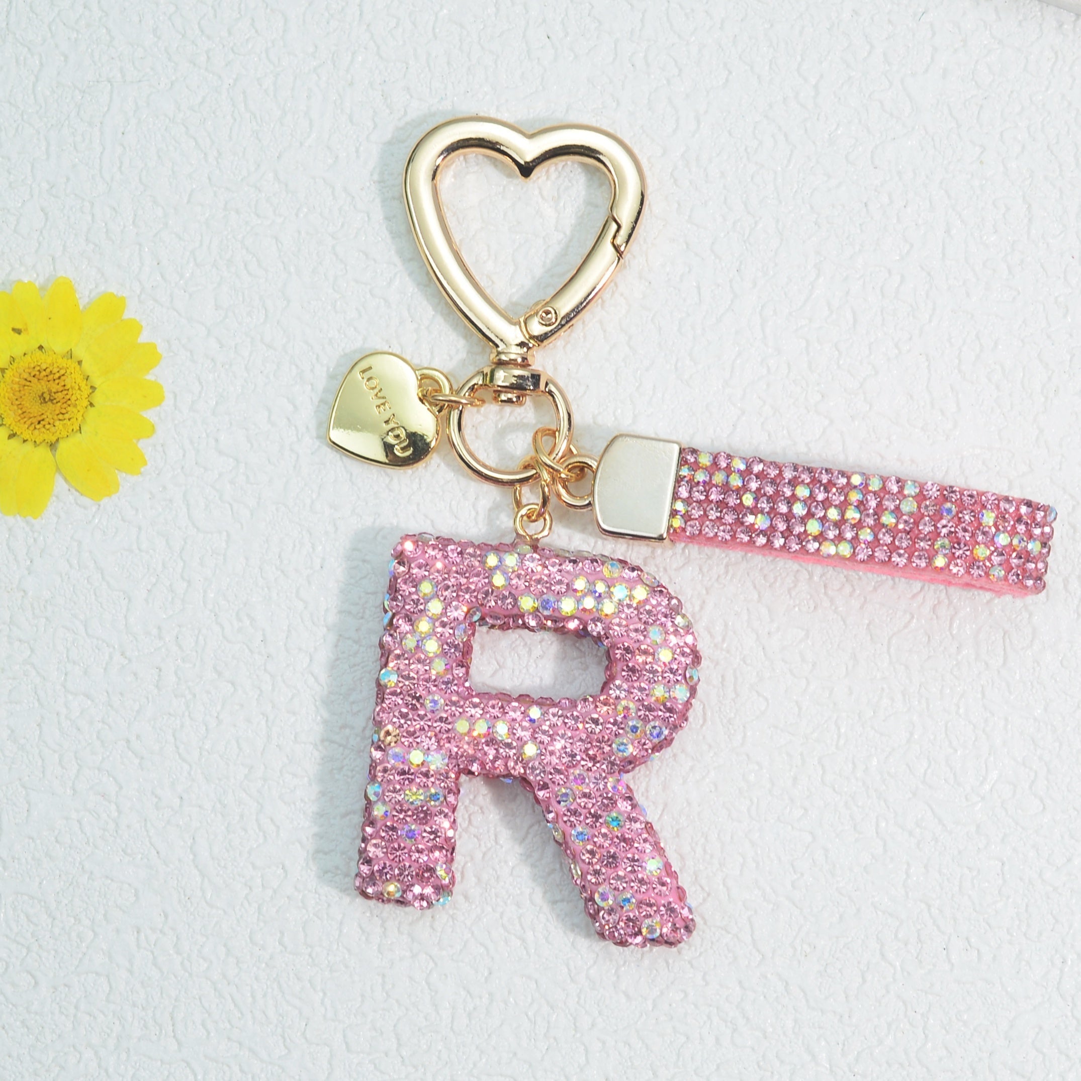 Llavero de PVC con iniciales de pedrería rosa y blanca con cierre de puño para mujeres