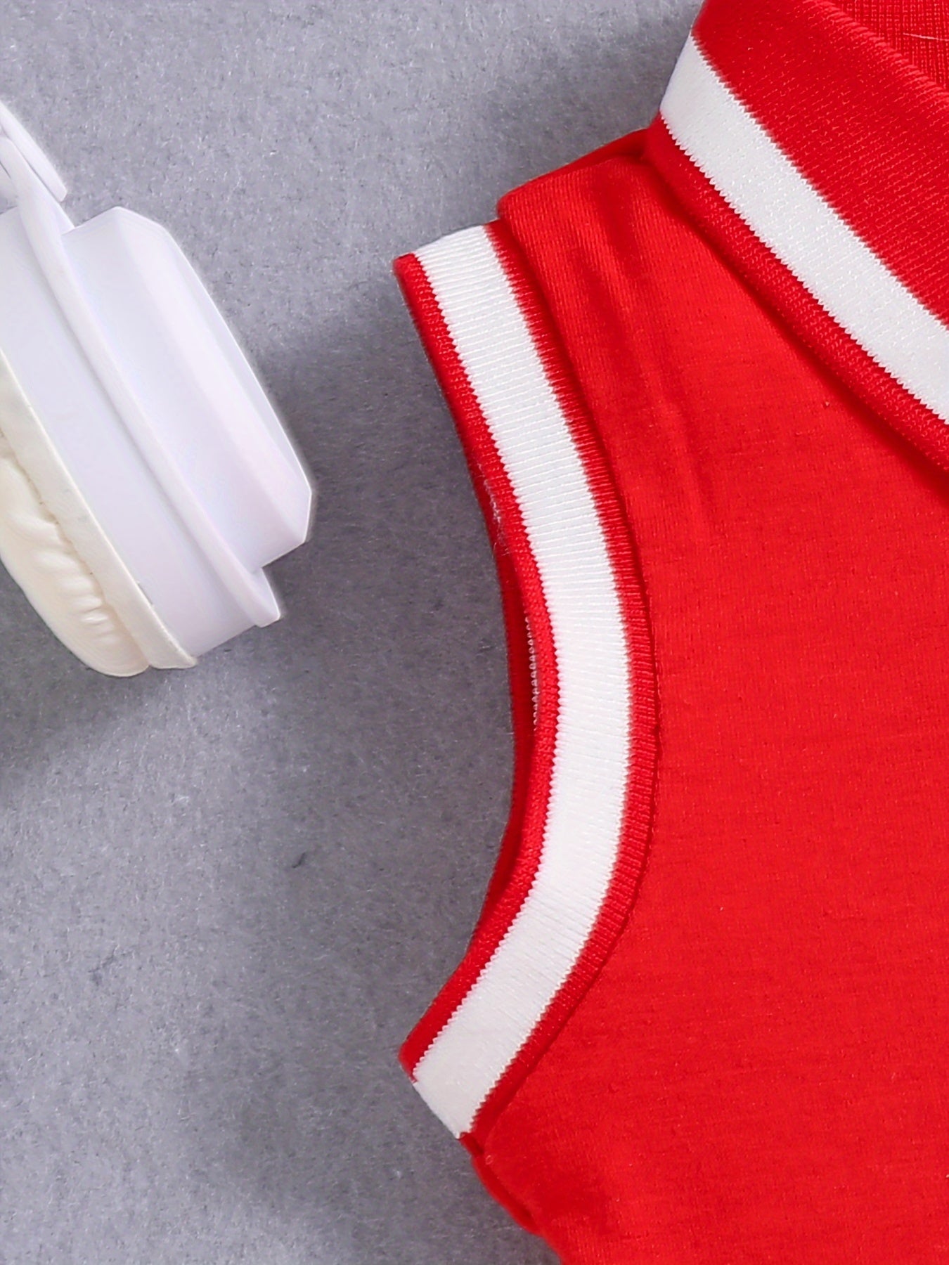 Qizlar uchun qizil tennis va sport libosi, nafas oladigan, teri so'radigan polyesterdan tayyorlangan, cho'ziluvchan va yengsiz dizayni bilan sport va tasodifiy kiyimlar uchun qora yozuvlar bilan sportiy nafislikni taqdim etadi.