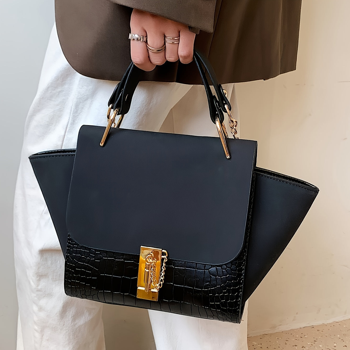 Metallik aksentlar, zanjirli belbog', burama qulflanish va polyester astar bilan bezatilgan zamonaviy khaki sumka.