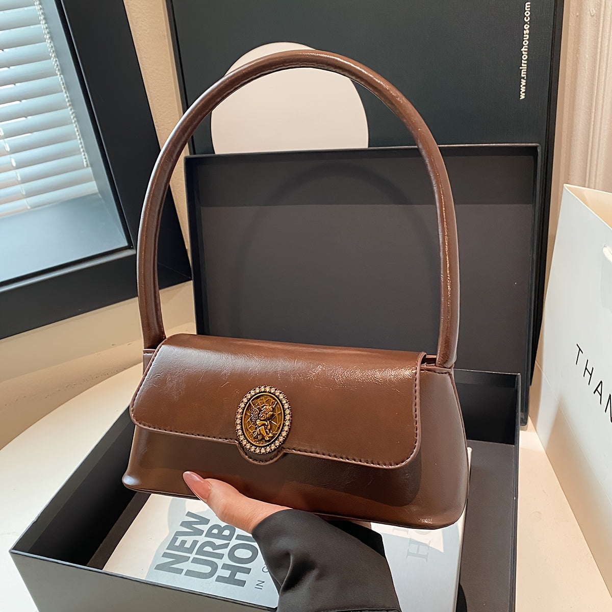 Ayollar uchun fransuz vintage uslubidagi yelka sumkasi, nafis jigarrang rangda, metall emblema, magnit yopish va polyester astar bilan. Har kuni foydalanish uchun ko'p funksiyali va zamonaviy.