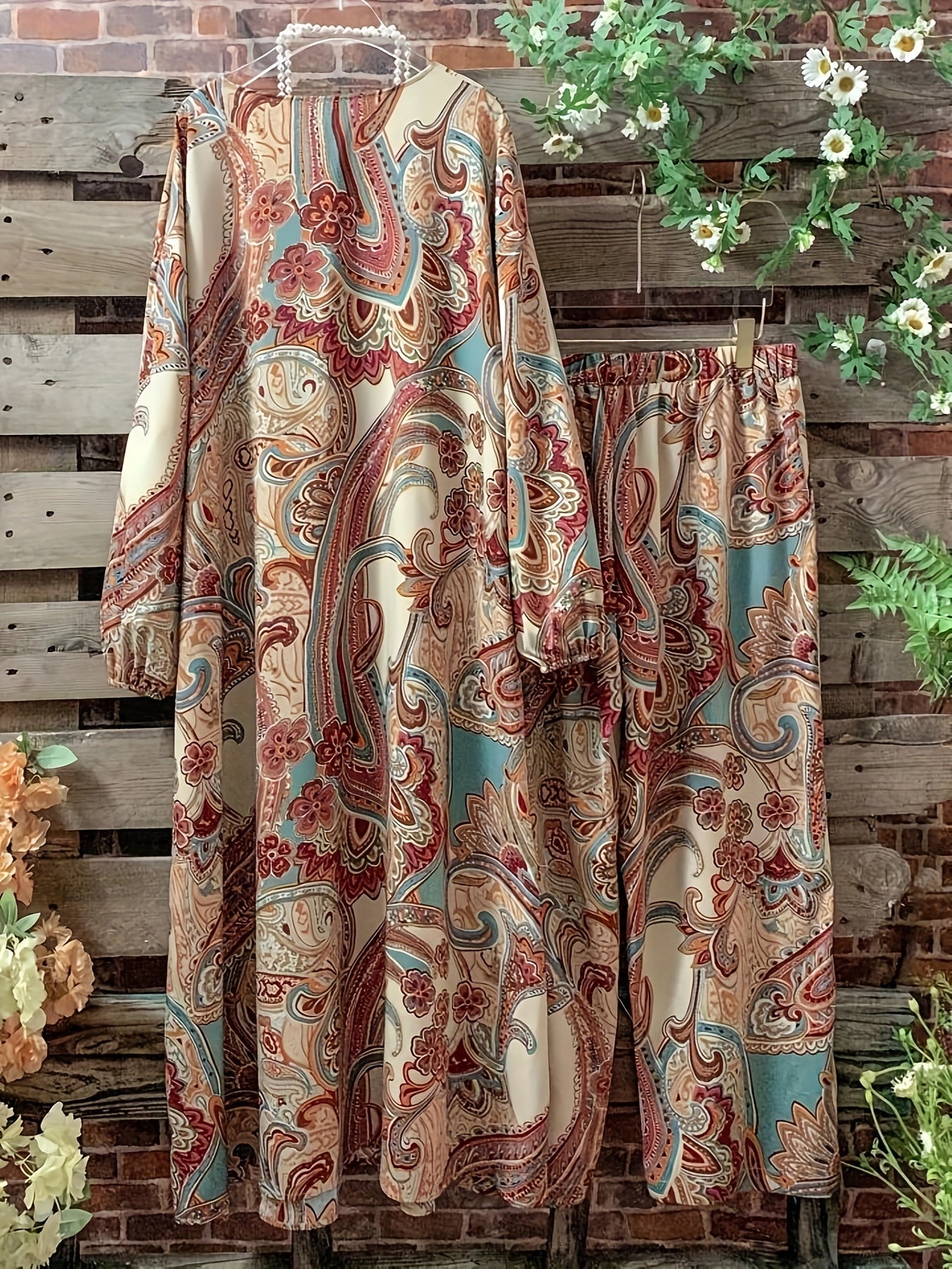 Katta o'lchamdagi ayollar uchun gullar naqshidagi ikki qismli to'plam ochiq old qismi va elastik belli shimlarni o'z ichiga oladi.