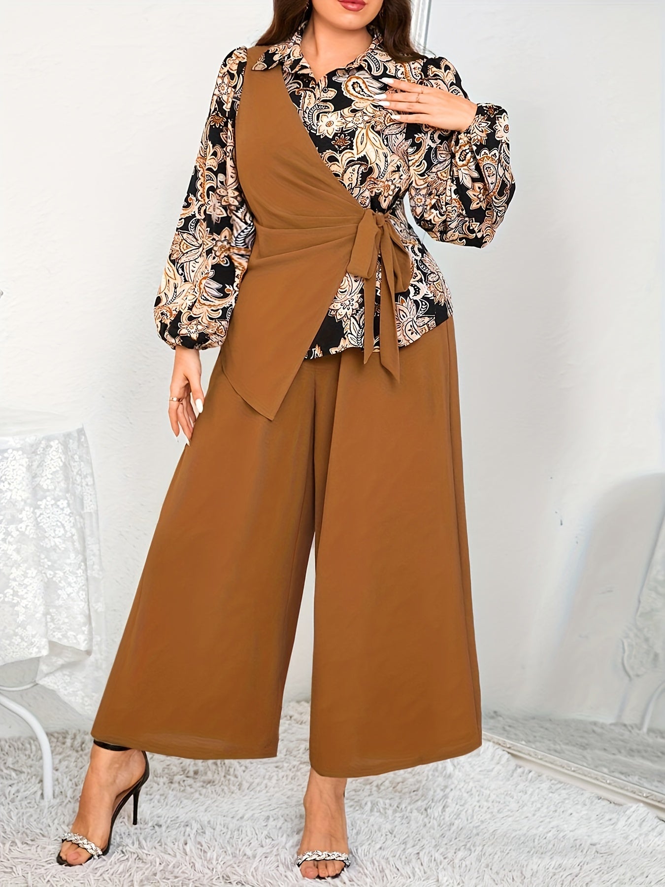 Katta o'lchamdagi ayollar uchun zamonaviy gullar bilan bezatilgan ikki qismli to'plam - bog'ichli bel detali va keng oyoqli shimlar bilan asimmetrik uzun qo'lqopli bluzka, mashinada yuvish mumkin, polyesterdan tayyorlangan.