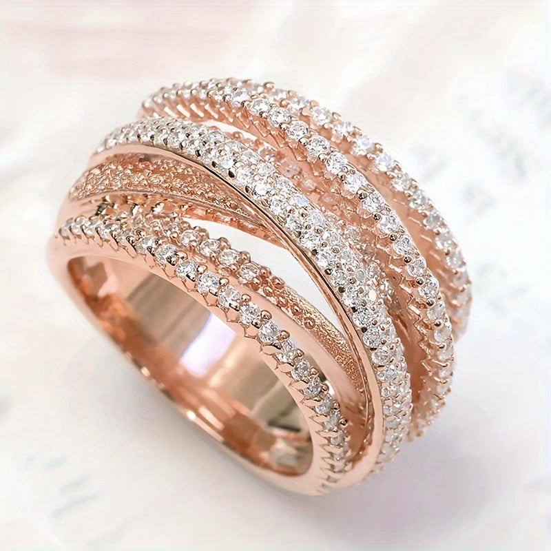 Ushbu zamonaviy halqa uzukning o'zingizga yoqadigan rangini tanlang, u porlaydigan zirconia bilan qoplangan, kumush, oltin yoki pushti oltinda o'zaro bog'langan dizayni bilan.