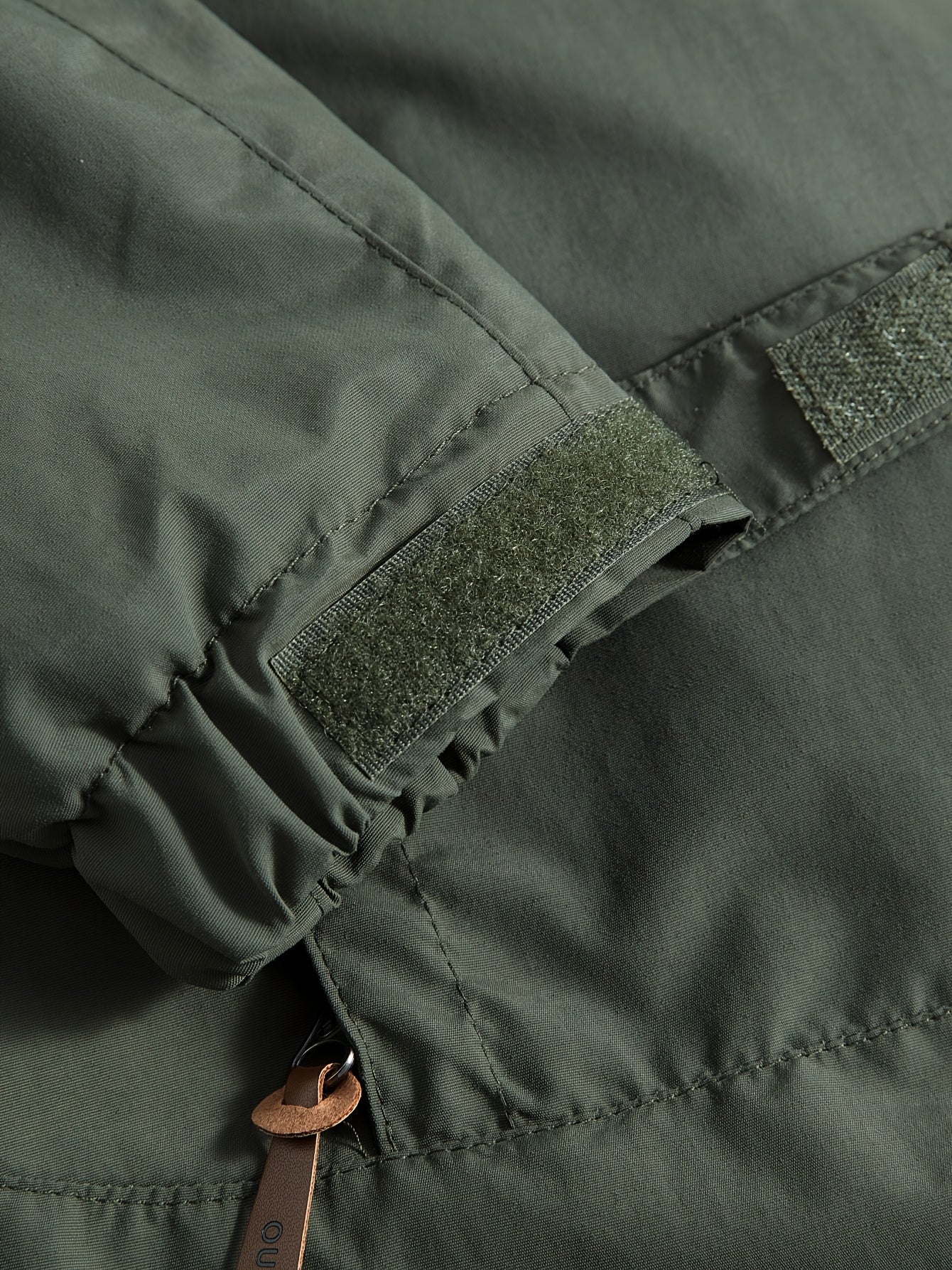 Erkaklar uchun suv o'tkazmaydigan, shamol o'tkazmaydigan, tikuvli dizaynga ega, bir nechta cho'ntaklari, krujka yelkalari, oddiy yenglari, fermuarli plakat bilan 100% polyester nylon materialidan tayyorlangan.