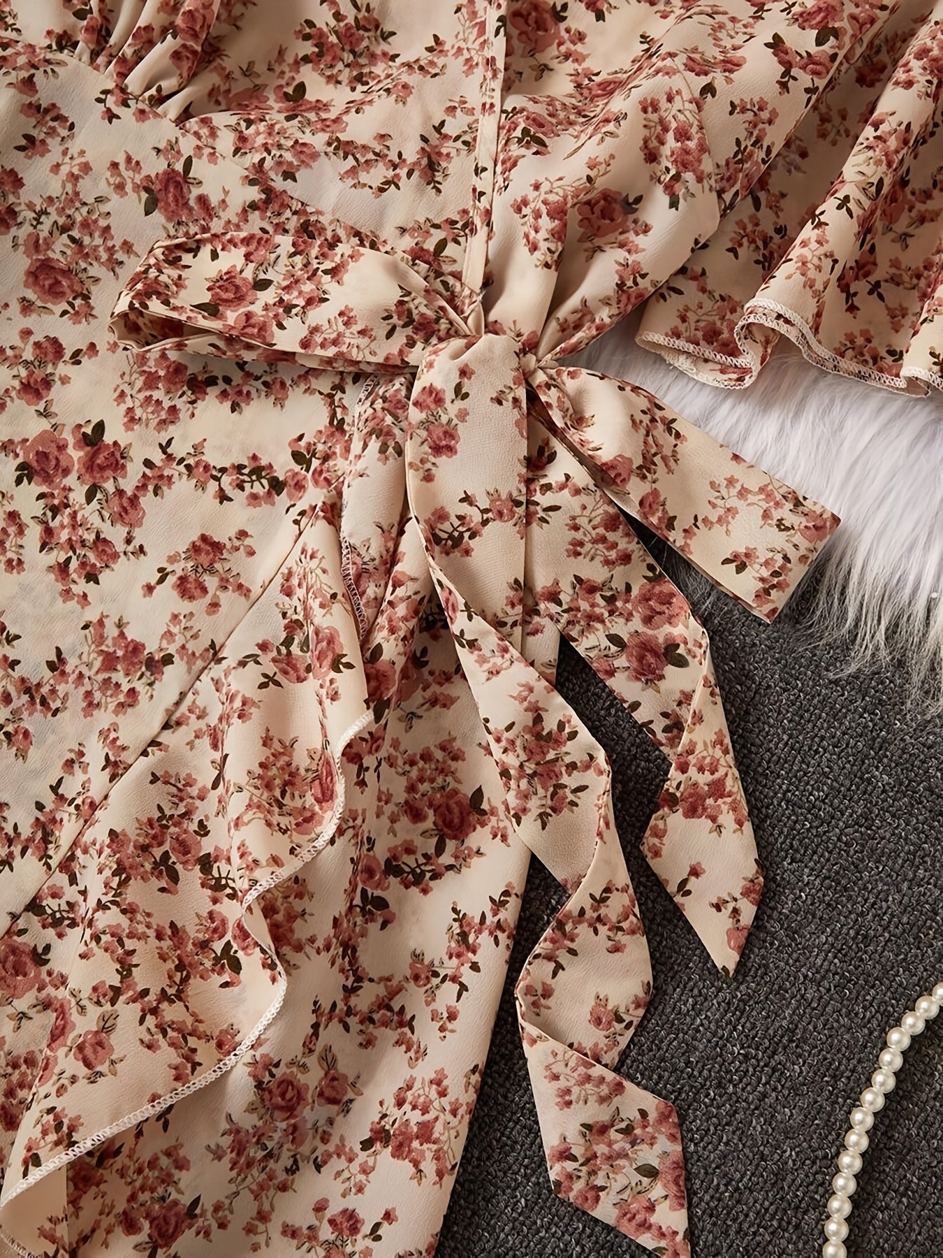 Ayollar uchun nafis gullar bilan bezatilgan libos, bohem uslubidagi qirralar, kesishgan bo'yin va ip bilan bog'lash detali. To'qilgan polyester matodan tayyorlangan, oddiy moslikda, belbog'ni o'z ichiga oladi. Har mavsum uchun mos.