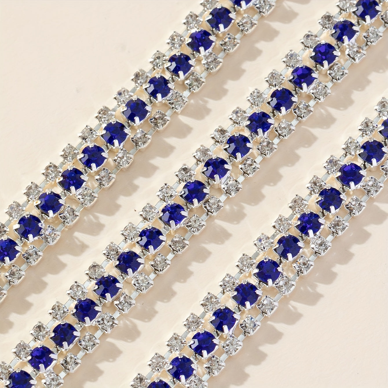 Ushbu 90 sm uzunlikdagi ko'p rangli rhinestone zanjiri 8# va 16# o'lchamdagi uch qator to'plardan iborat. Bu poyabzal, kiyim, sovg'a qutilari va turli DIY loyihalariga porloq qo'shish uchun mukammaldir.