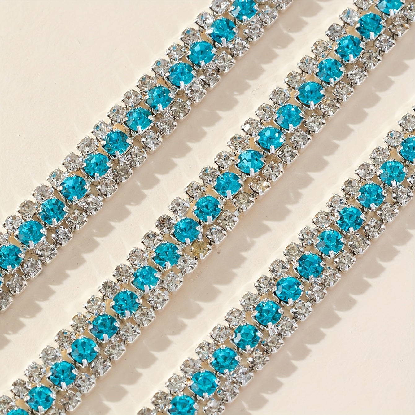 Ushbu 90 sm uzunlikdagi ko'p rangli rhinestone zanjiri 8# va 16# o'lchamdagi uch qator to'plardan iborat. Bu poyabzal, kiyim, sovg'a qutilari va turli DIY loyihalariga porloq qo'shish uchun mukammaldir.