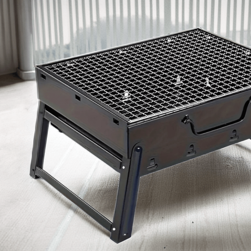 Parrilla portátil plegable de acero inoxidable, perfecta para acampar, hacer picnic y cocinar al aire libre. Diseño compacto y duradero.
