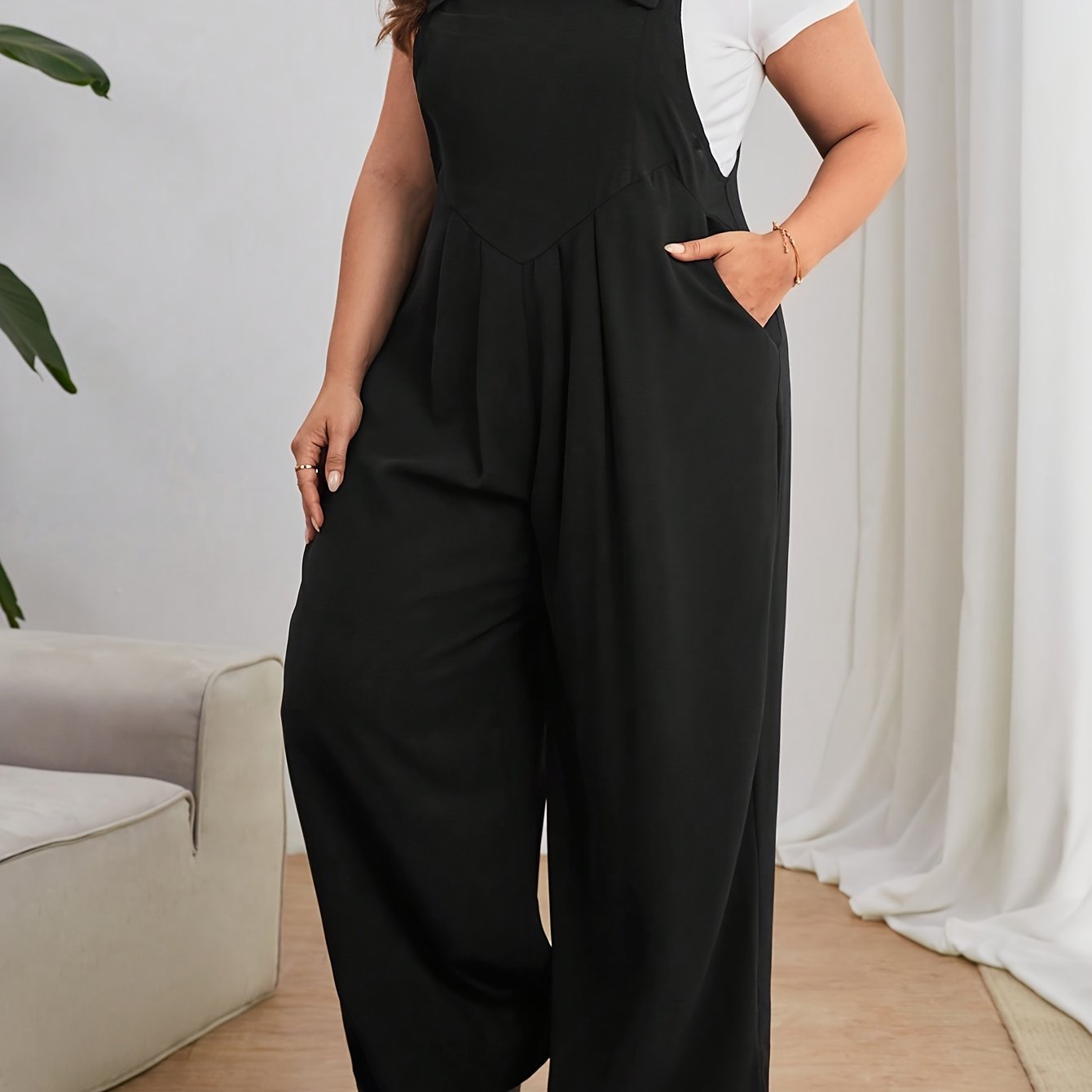 Keng oyoqli plussayz kombinezon, oddiy uslubda, bir rangli polyester matodan tayyorlangan. Yengsiz dizayn, cho'ntaklar bilan, barcha mavsumlar uchun mos.