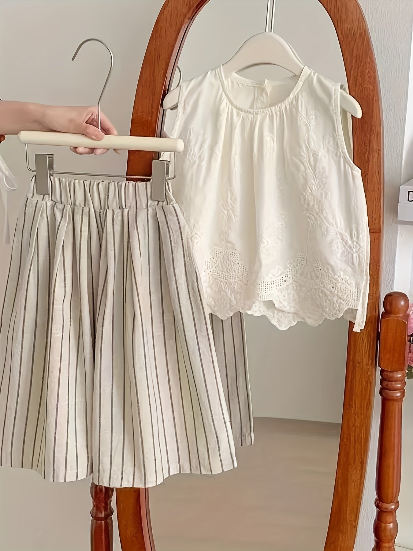 Yoz uchun qizlar uchun retro o'rmon uslubidagi kiyim, ko'ylaksiz jiletda va chiziqli keng oyoq shimlarda tikuvli tafsilotlar bilan.