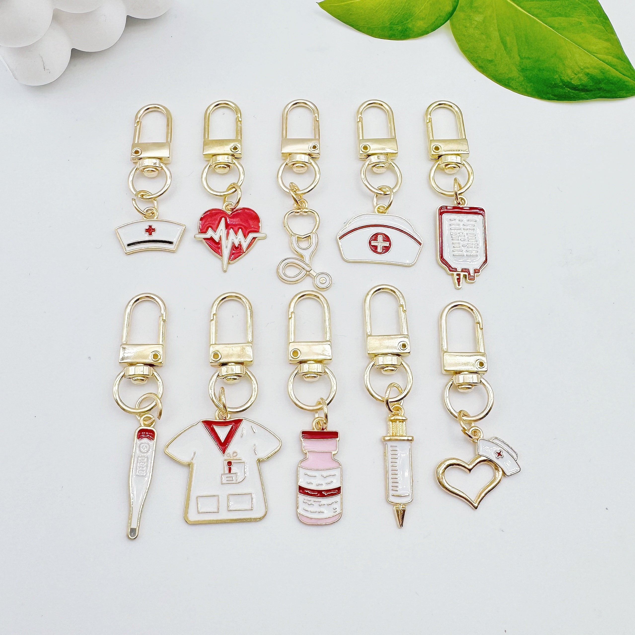 10 ta hamshira mavzusidagi qotishma kalit zanjirlar to'plami, karikatura tibbiy charm va professional bezakli kalit halqalari bilan, dumaloq halqa qopqog'i va to'rtburchak shakllari bilan. Hamshira kuni sovg'alari va bezaklari uchun mukammal.