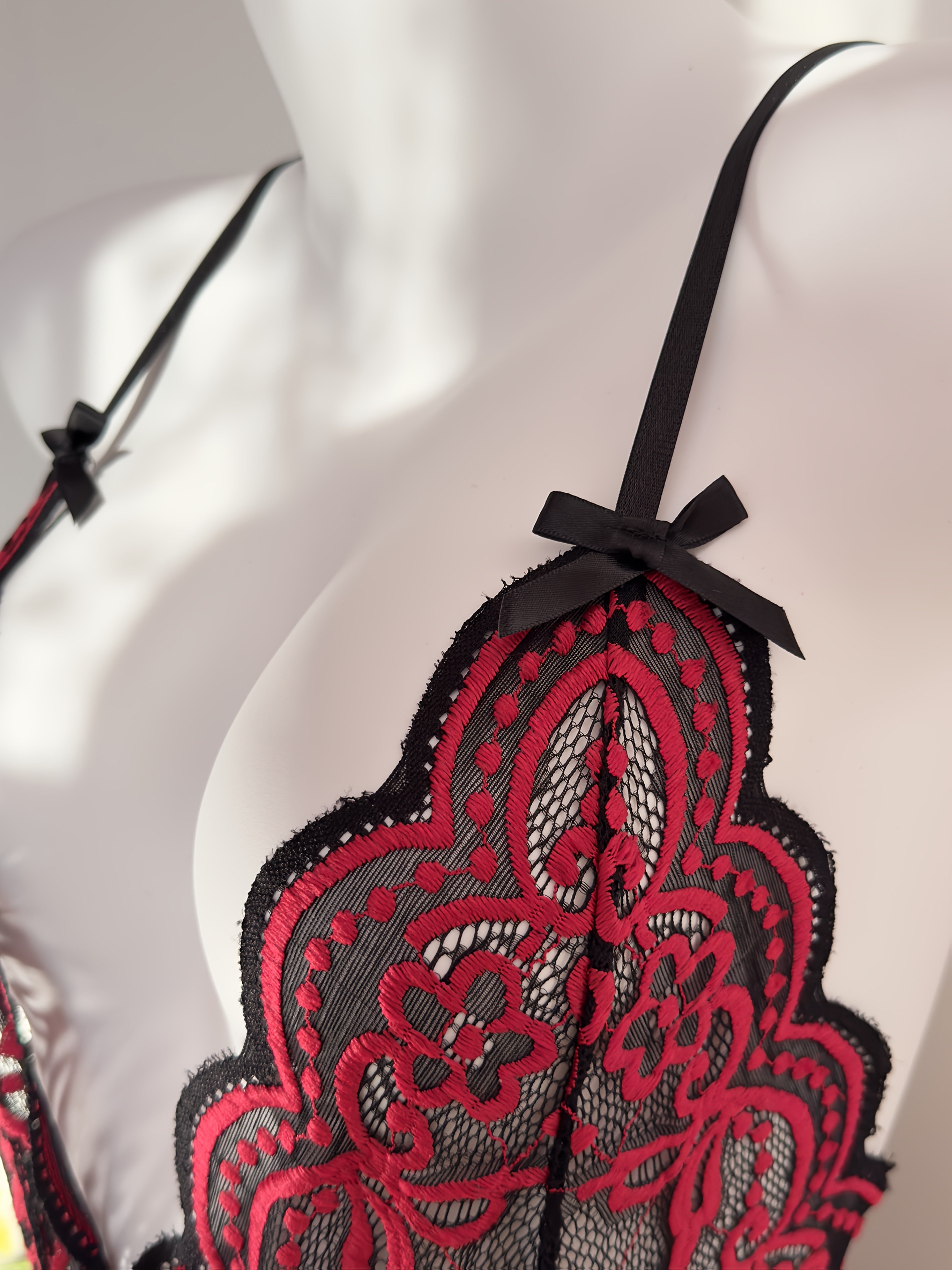 Jozibali dantel bodysuit, chuqur V-shakl, ochiq orqa va kesish tasma dizayni bilan.