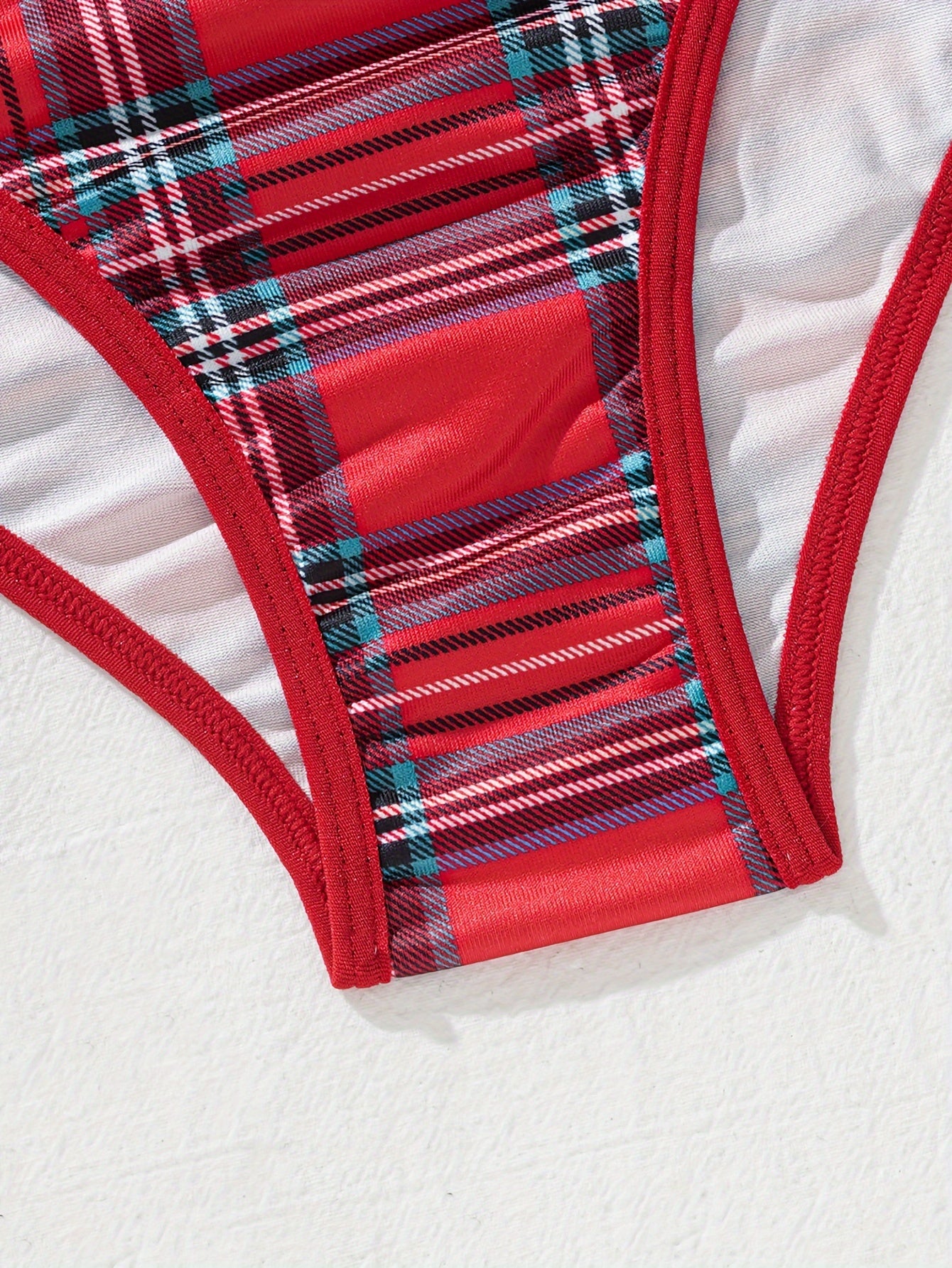 Комплект женского белья в клетку, изготовленный из 95% полиэстера и 5% эластана. Включает бюстгальтер средней поддержки и трусики средней посадки в дизайне с цветными блоками. В комплект не входит прокладка для груди. Часть взрослого белья.