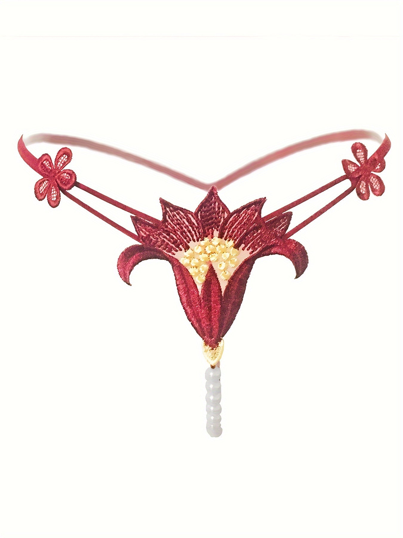 Красный кружевной корсет с перловыми деталями и соответствующим низким стрингом, украшенным цветами крючком и бисерными элементами.