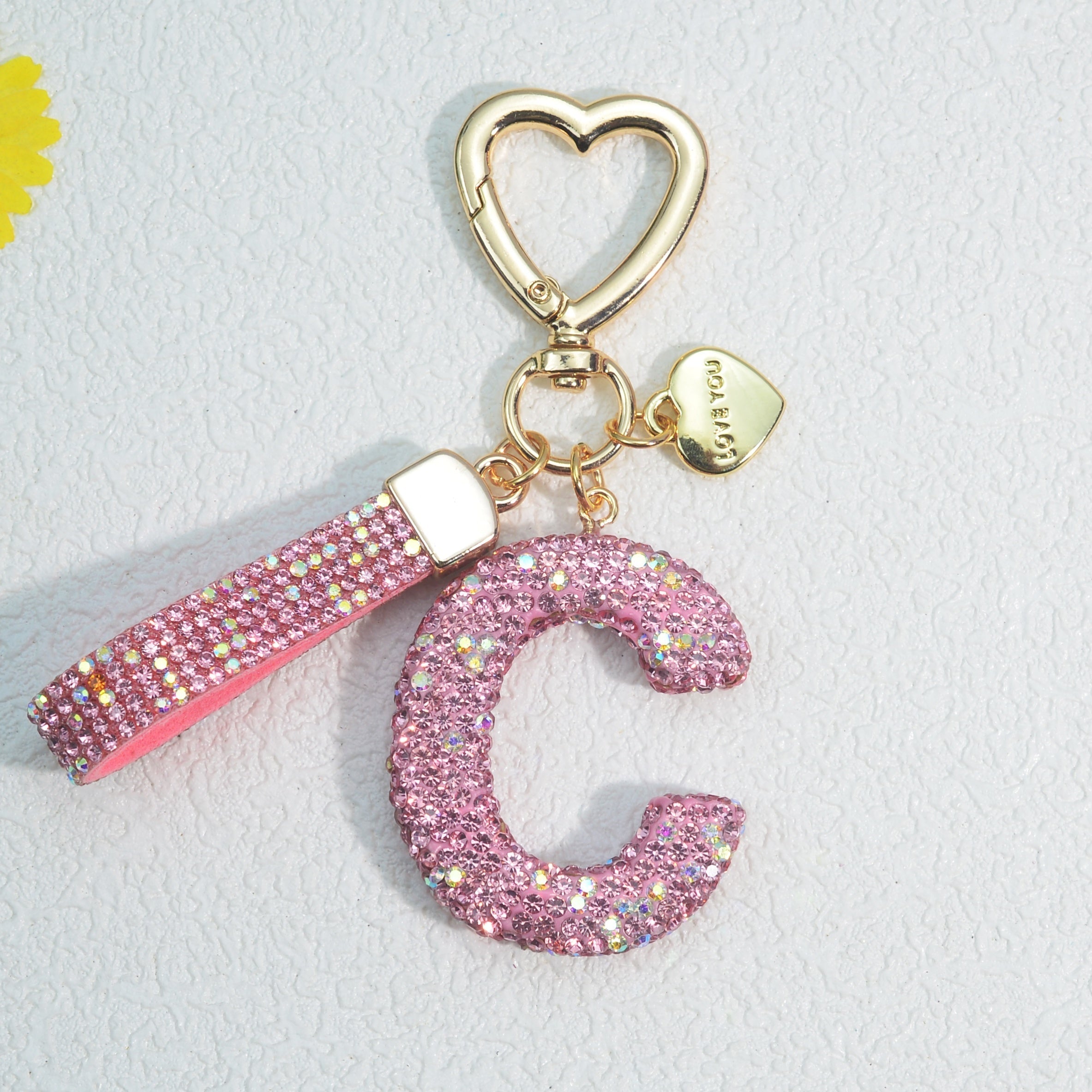 Llavero de PVC con iniciales de pedrería rosa y blanca con cierre de puño para mujeres