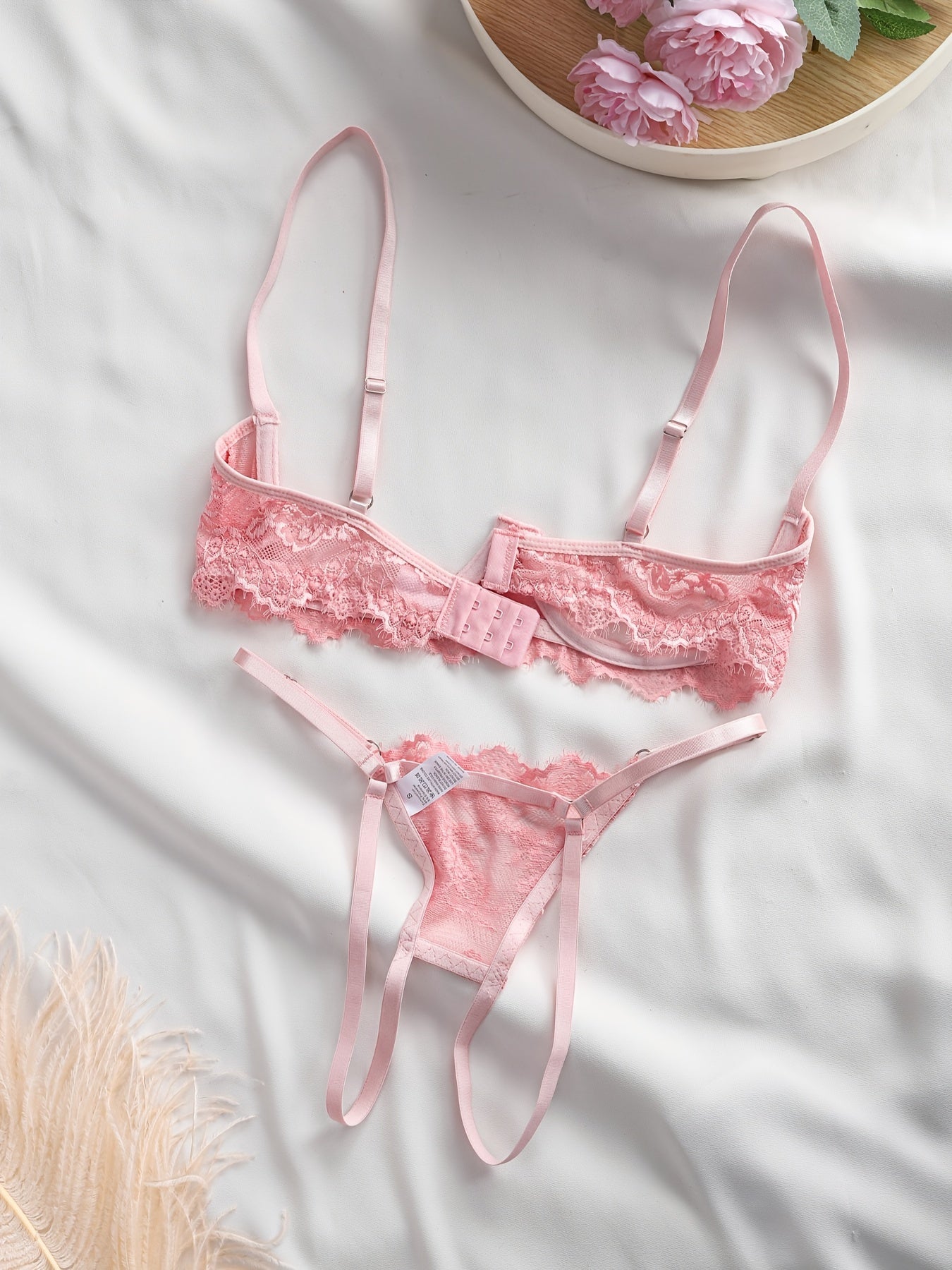 Gul dizayni, nozik kamarlar va orqa qismi ochiq kesimga ega bo'lgan ayollar uchun dantel ichki kiyim to'plami.