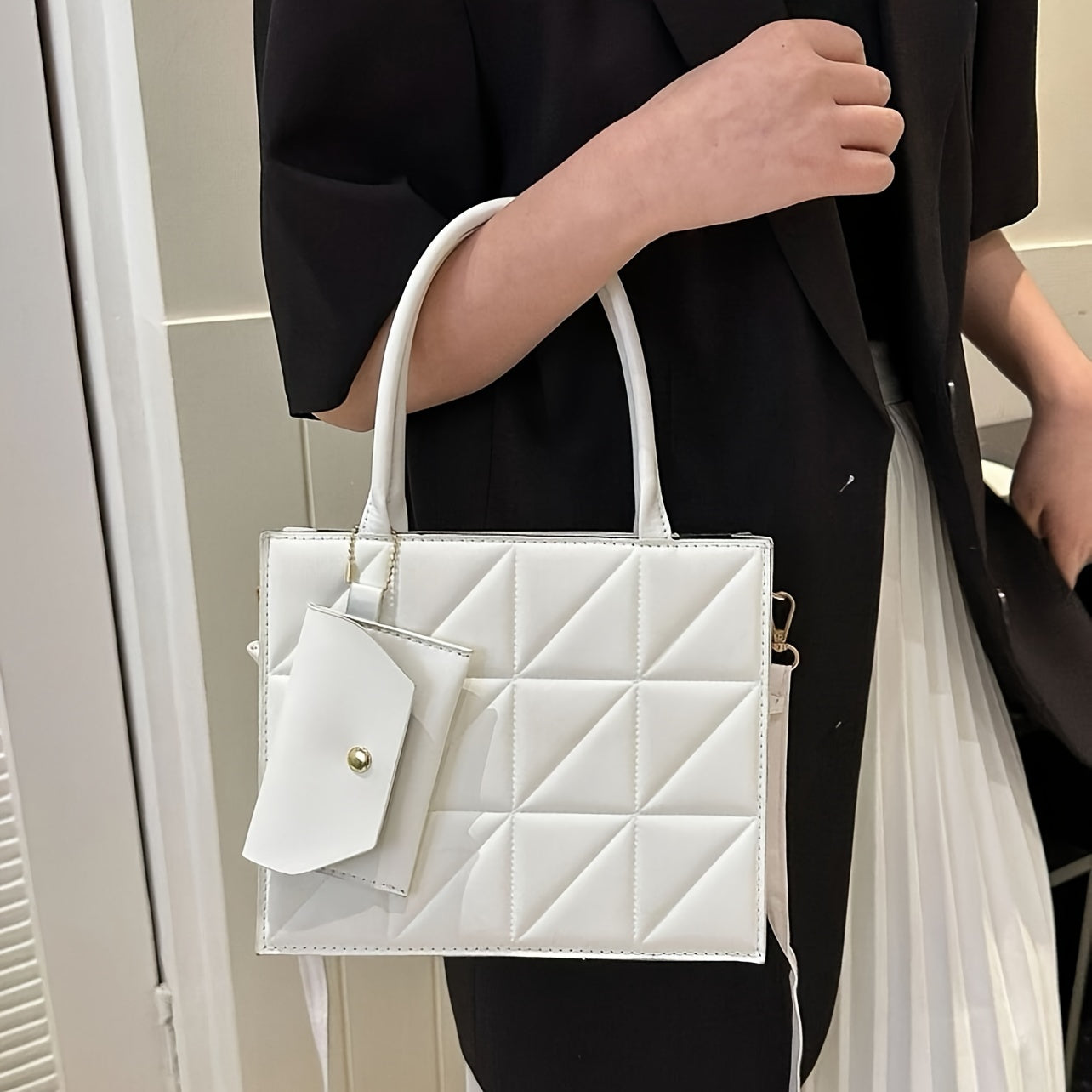 Qora qoplangan sintetik charm sumkasi, oltin detallari va ajraladigan uzun cho‘ntak bilan