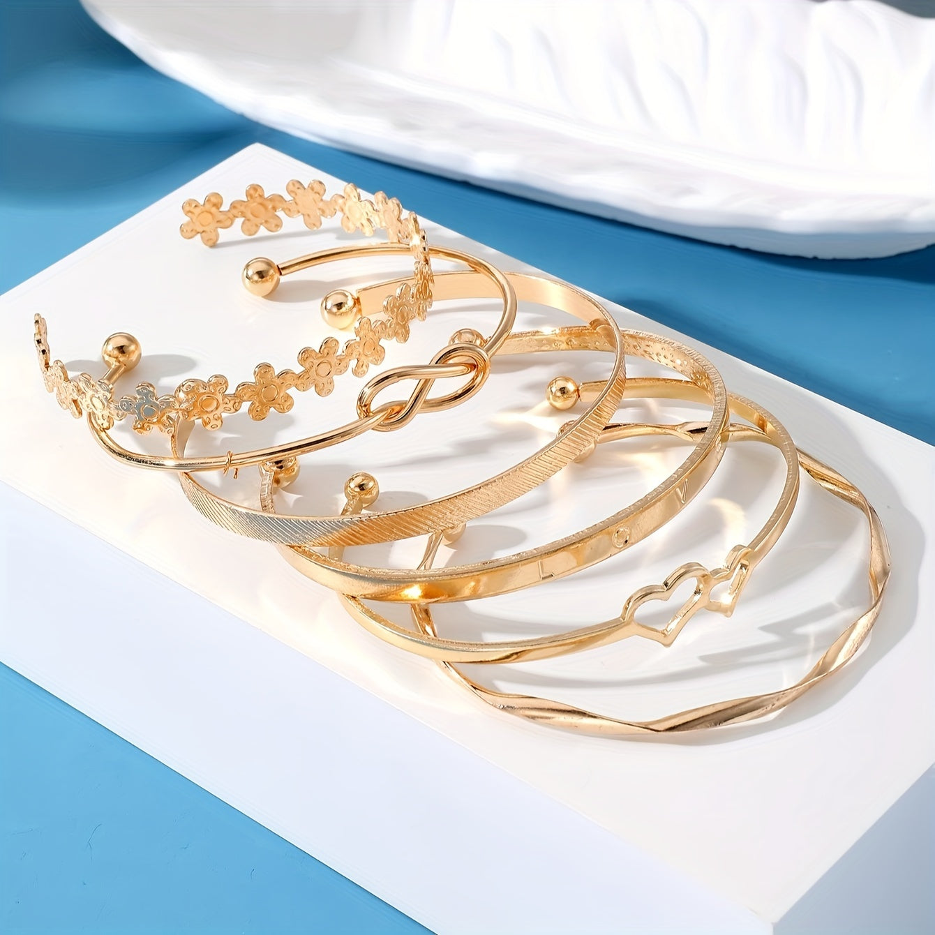 6 ta zamonaviy bilaguzuklar to'plami, gullar, tugunlar va yurak dizaynlariga ega. Ularni kundalik kiyimlaringiz yoki bayram kiyimlaringiz bilan birlashtiring. Ushbu sozlanadigan zargarlik buyumlari har qanday ko'rinishni bezatish uchun mukammaldir.