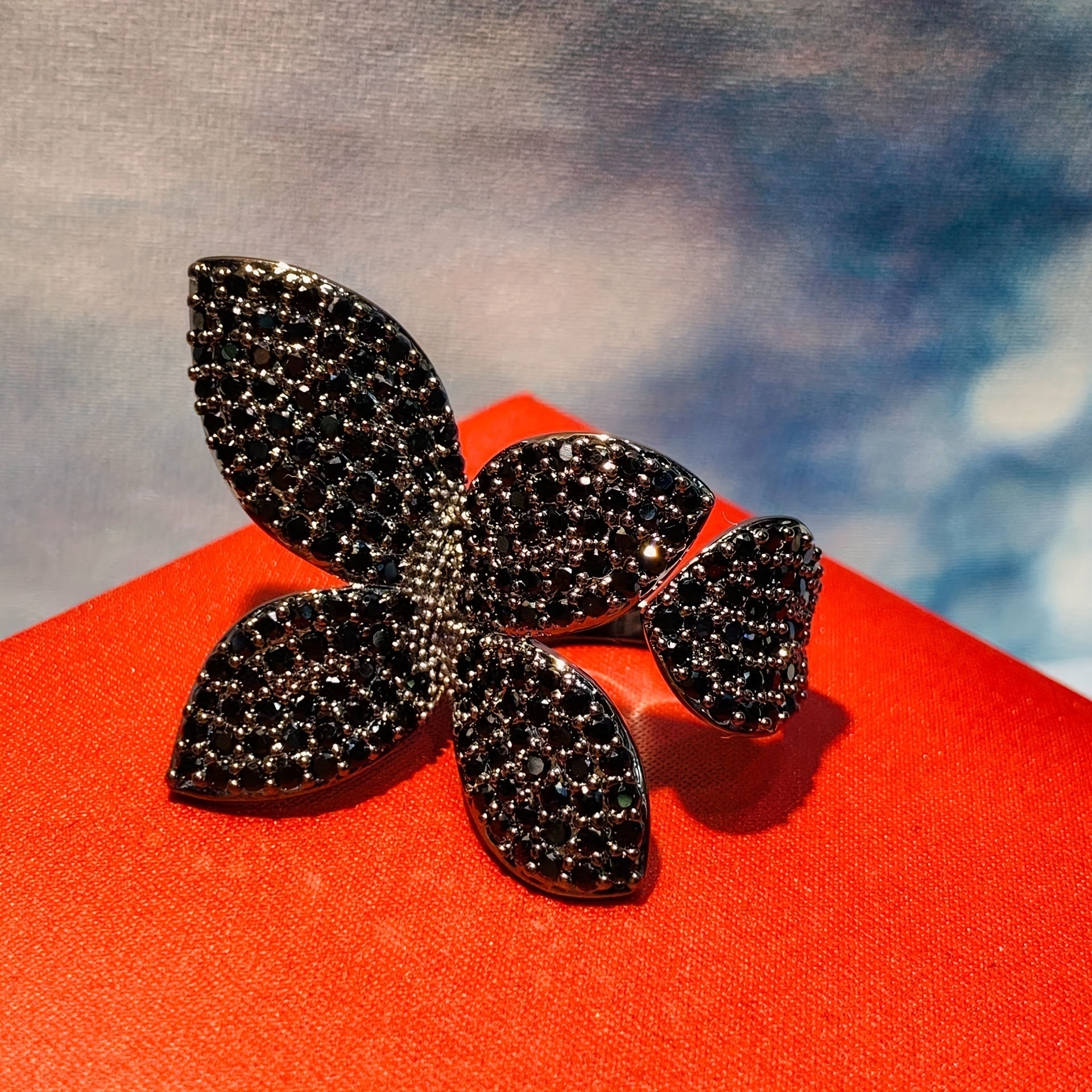 Zirconiyadan tayyorlangan to'liq uch o'lchovli to'rt yaproqli gullar uzukini o'z ichiga olgan zamonaviy va murakkab uniseks onlayn mashhur aksessuar.