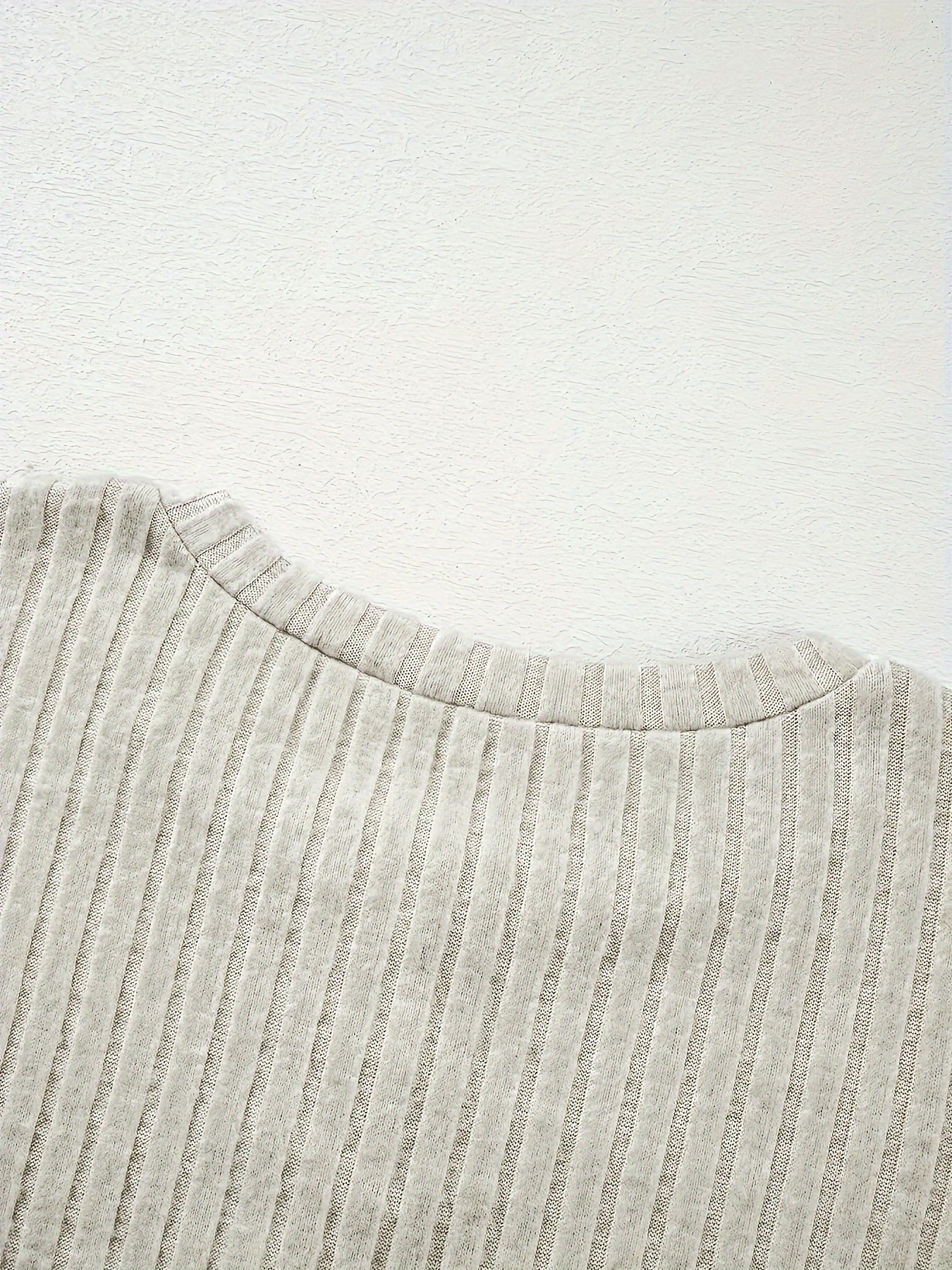 Представляем нашу новую коллекцию осень/зима для женщин: стильный комплект из двух предметов с длинными рукавами, текстурированным однотонным цветом, фальшивыми пуговицами и рифлеными спущенными плечами для повседневного образа.