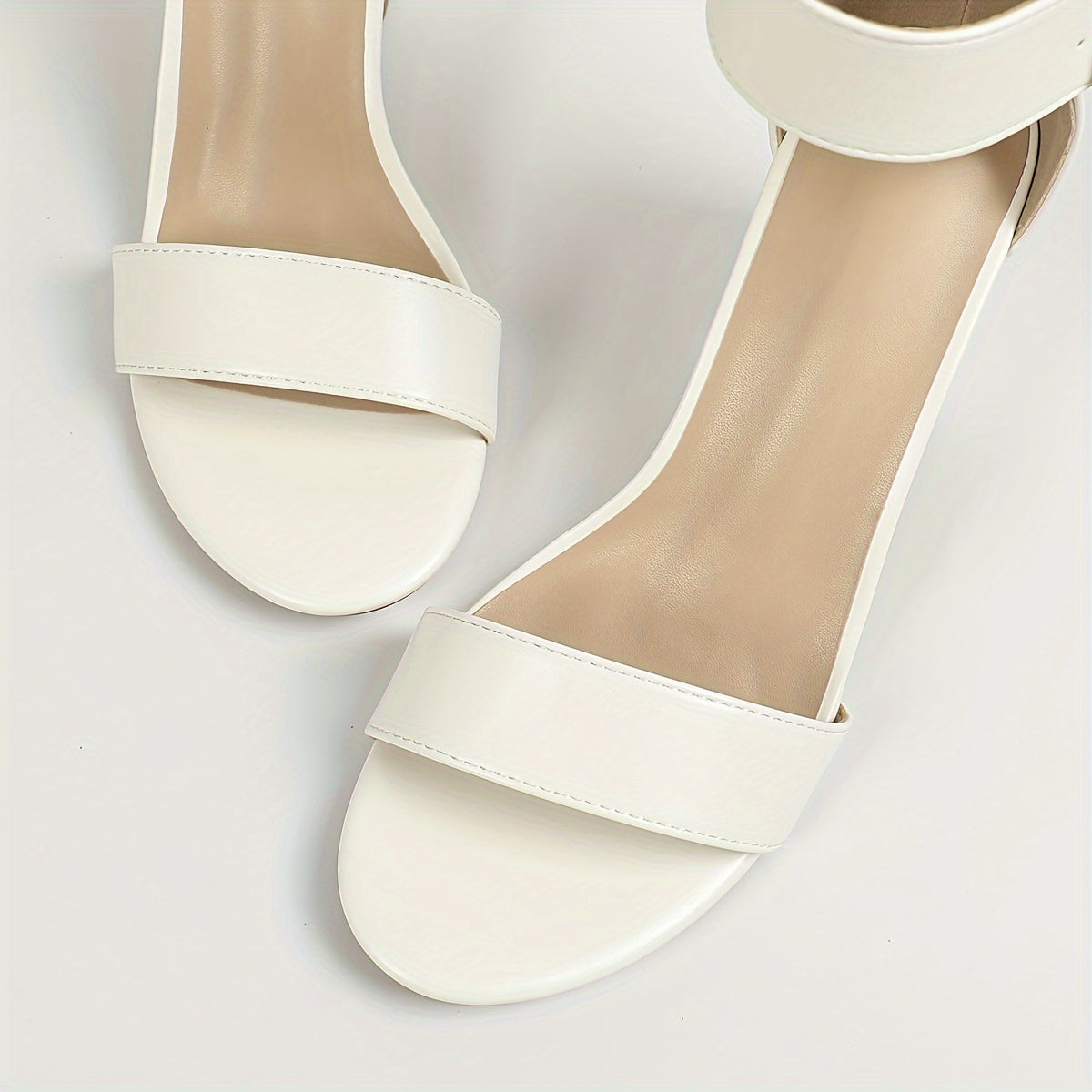 Qulupnay oyoq bilagida tasma va ochiq barmoq bilan zamonaviy oq blok tovonli sandlelar, har qanday holat uchun mos va qulay.