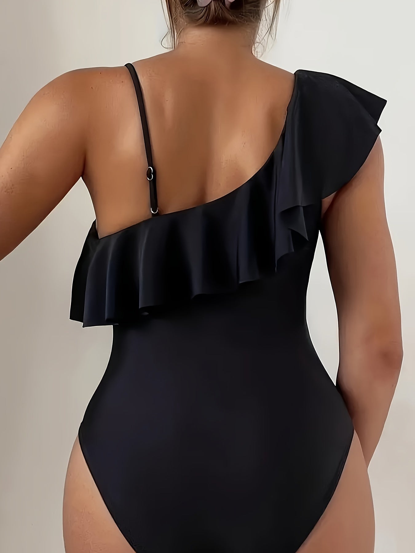 Qora tarmoq bir qismli suzish kostyumi, asimmetrik bo‘lakli ruffles va olib tashlanadigan qavat bilan