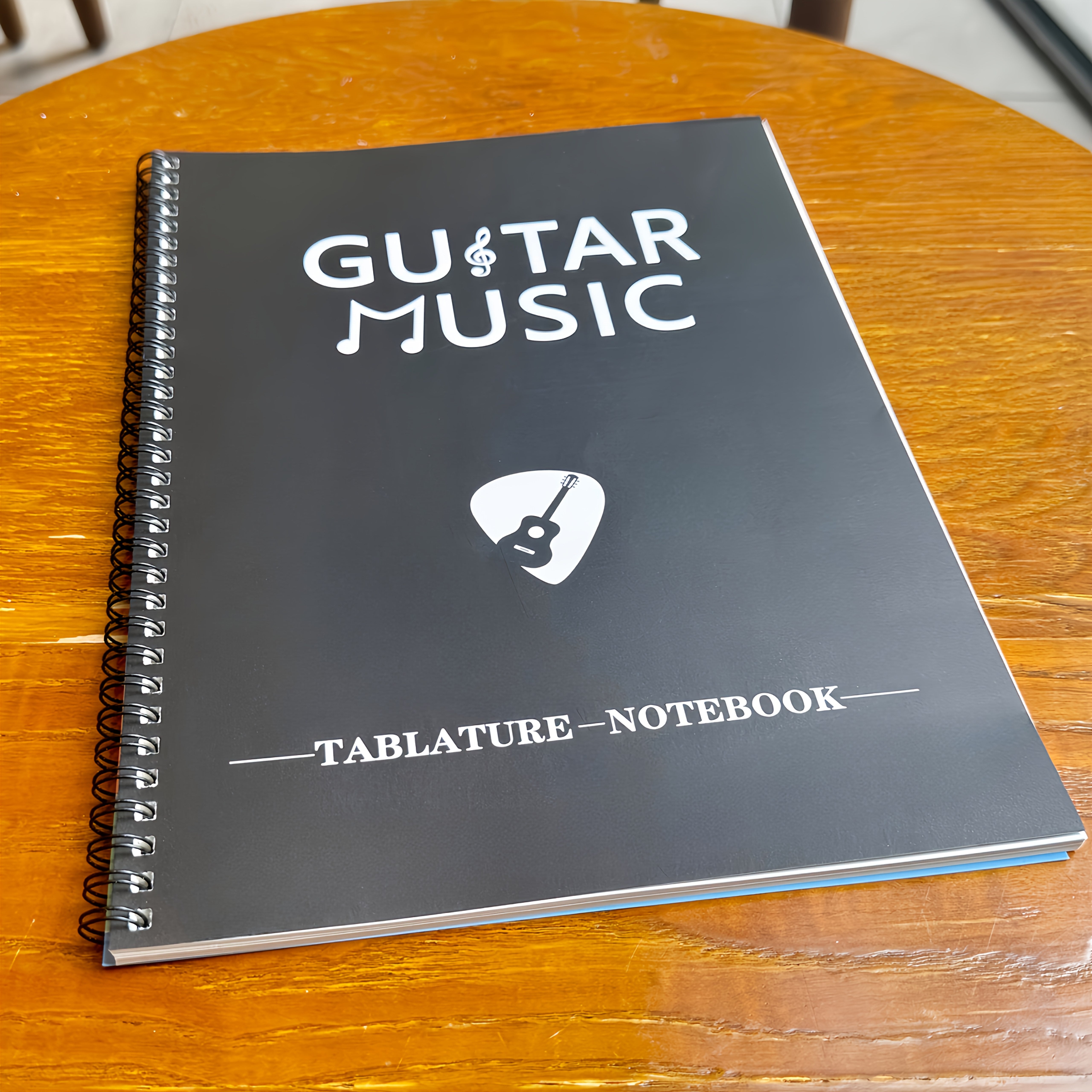 Cuaderno de práctica de guitarra con 50 hojas en blanco con pentagramas y diagramas de acordes