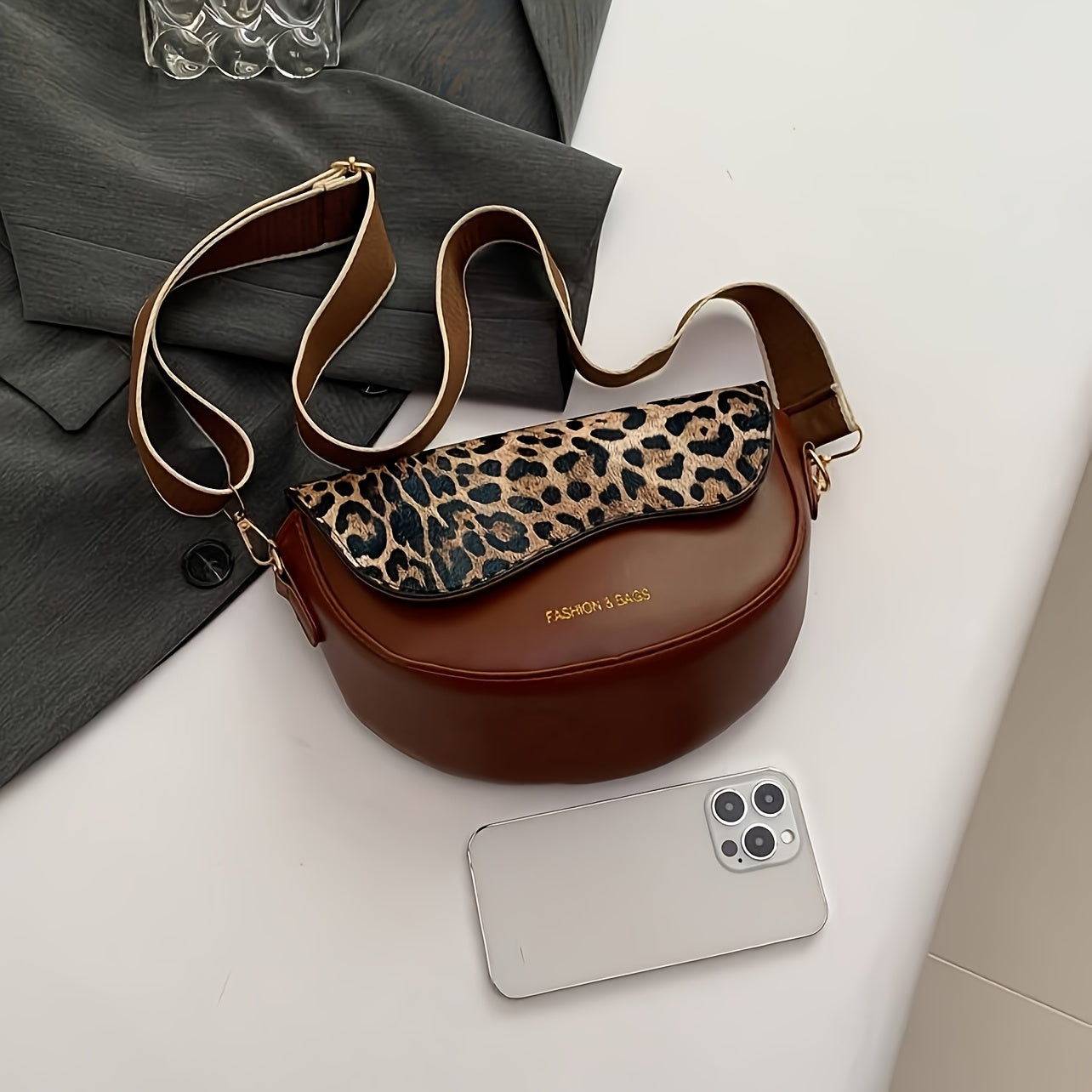 Vintage uslubidagi leopard naqshli qopqoq va magnit yopilishi bo'lgan qora va jigarrang sintetik charmdan tayyorlangan crossbody sumka, ochiq havoda ko streetwear va bayram sovg'alari uchun mukammal.