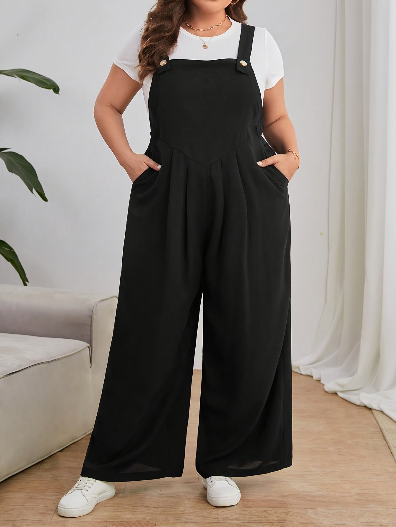 Keng oyoqli plussayz kombinezon, oddiy uslubda, bir rangli polyester matodan tayyorlangan. Yengsiz dizayn, cho'ntaklar bilan, barcha mavsumlar uchun mos.