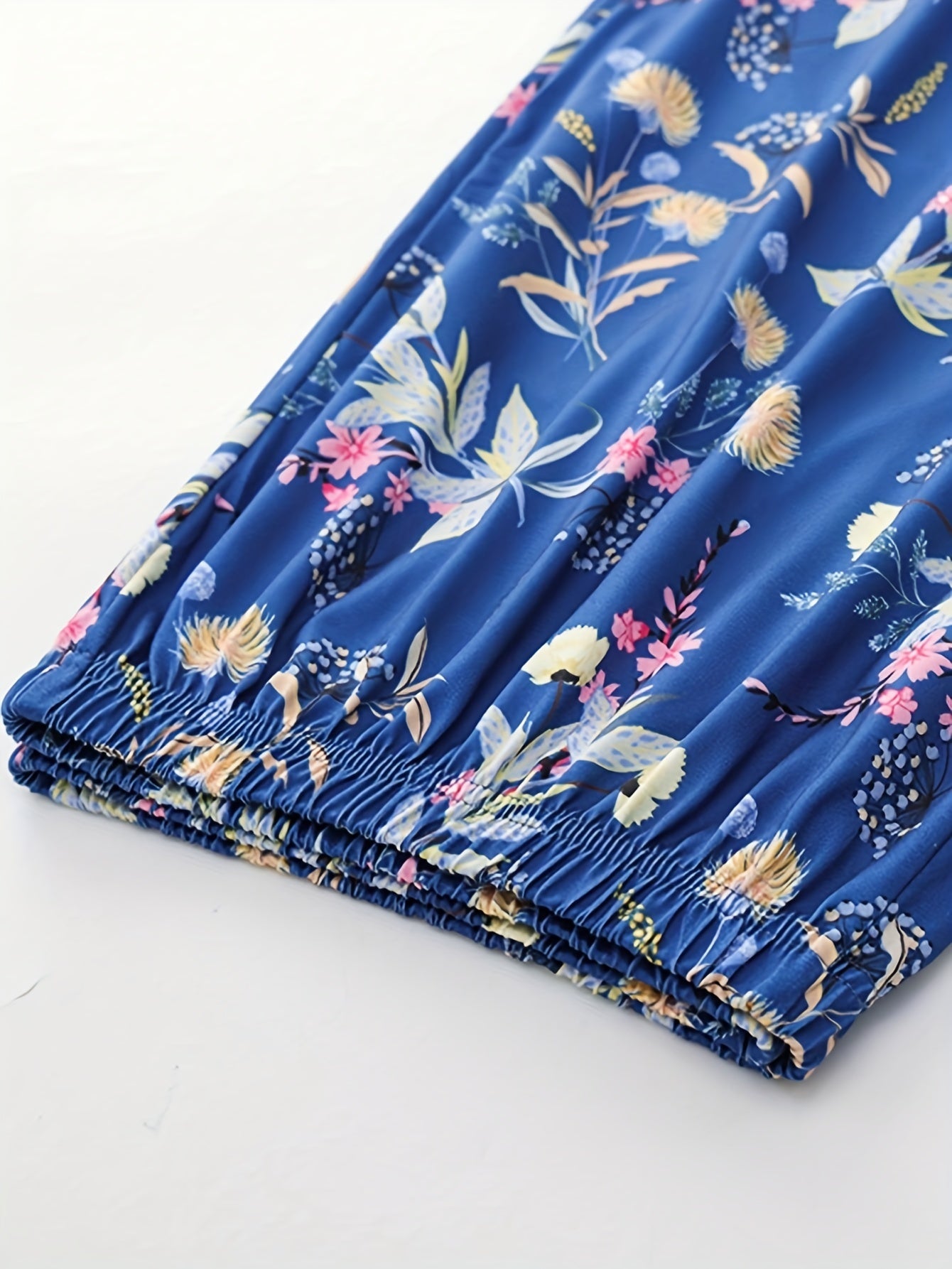 Ayollar uchun yozgi pijama to'plami tasodifiy gullar printi bilan qisqa yengli yuqori va 95% polyester va 5% elastan dan tayyorlangan qisqa shimlardan iborat bo'lib, uyda qulaylik uchun ozgina cho'ziladigan to'qima bilan ta'minlangan.