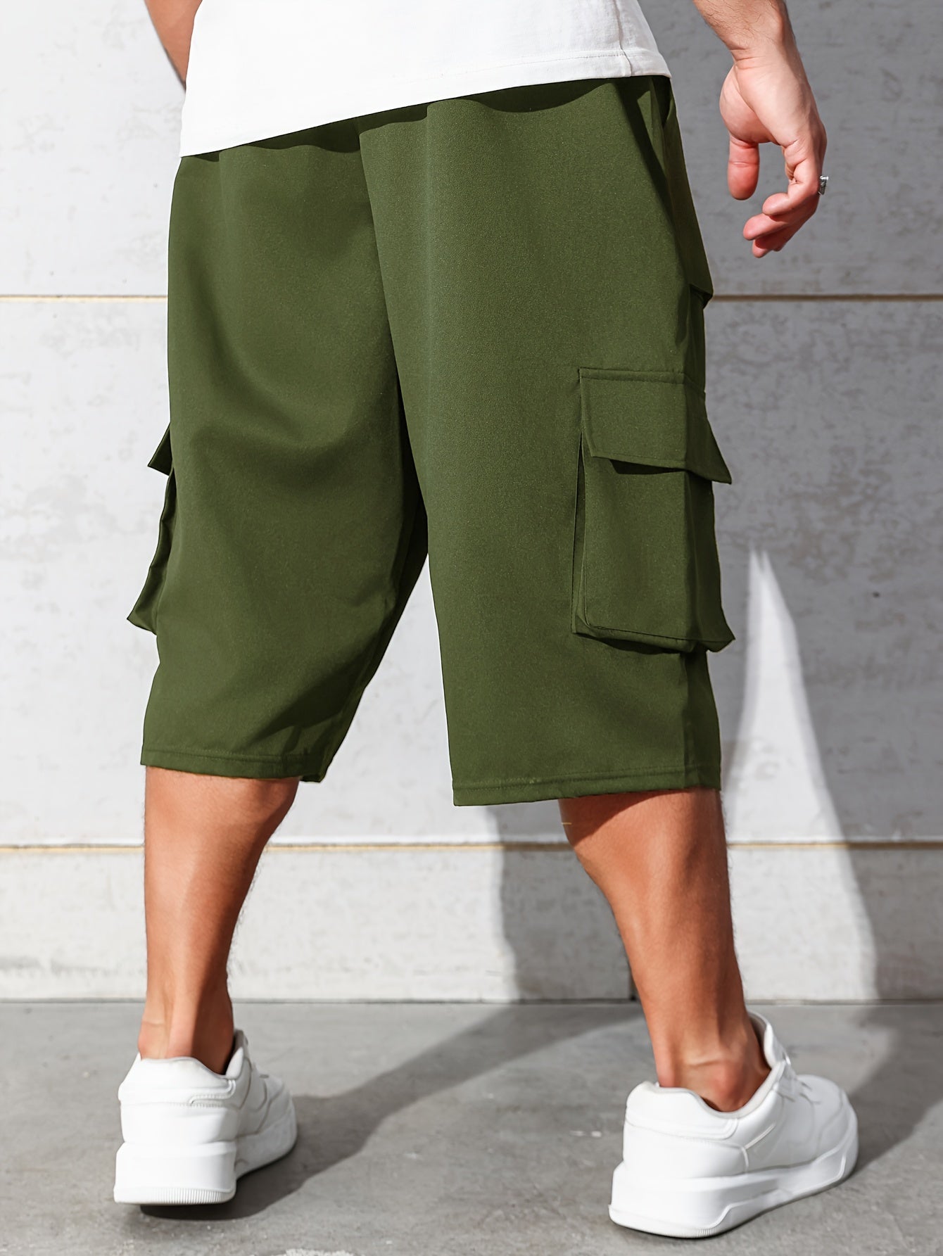 Erkaklar uchun bo'shashgan kesimdagi tizzagacha bo'lgan kargo kapri shimlar, bir nechta cho'ntaklar va tortish belbog'i bilan kattalar o'lchamida.