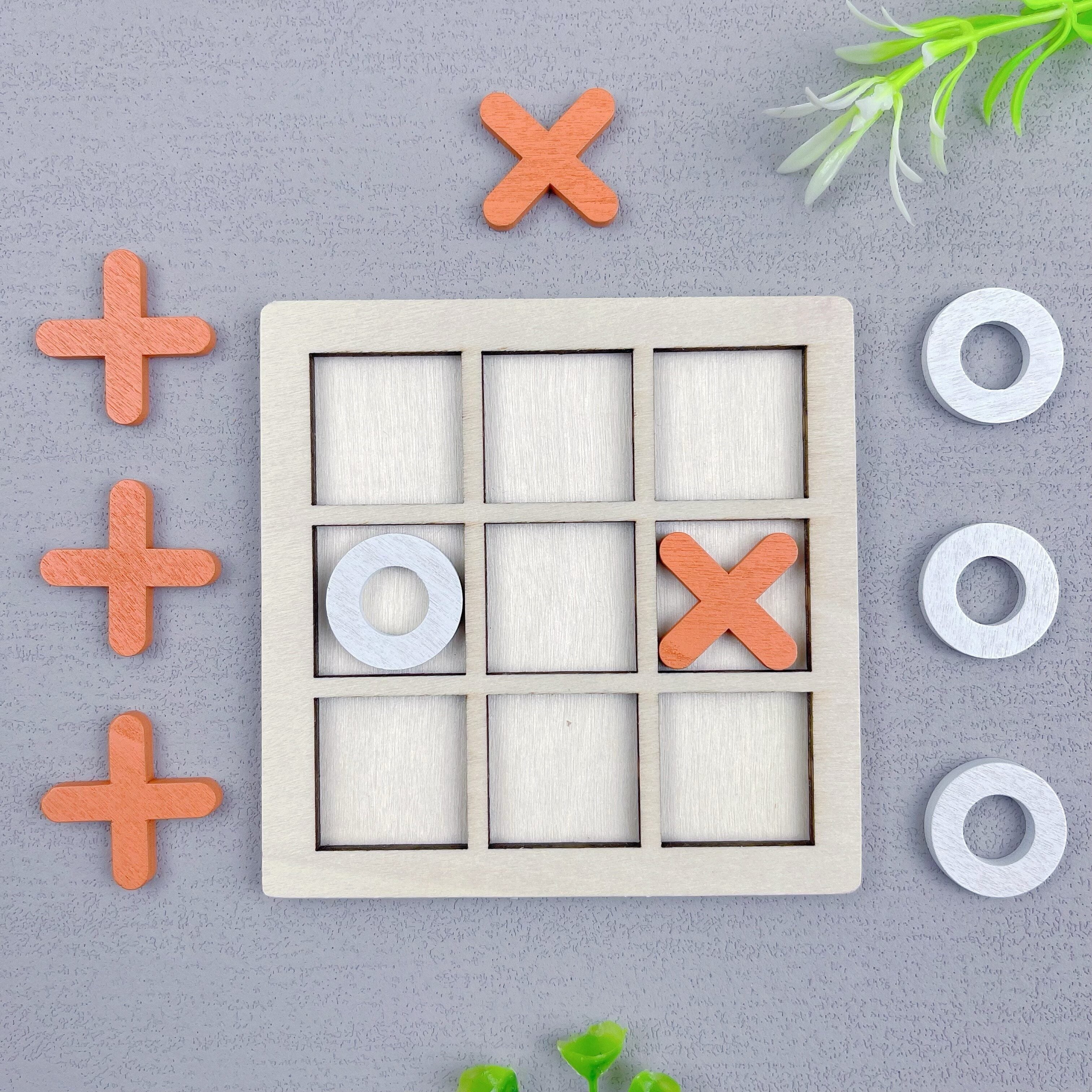 Ta'lim beruvchi, ikki o'yinchi uchun Tic Tac Toe o'yini, turli rangdagi yog'och XO qismlari bilan.