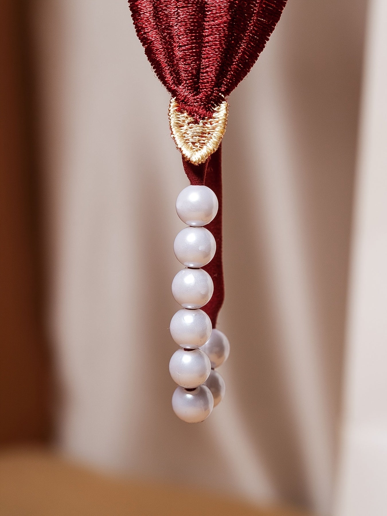 Красный кружевной корсет с перловыми деталями и соответствующим низким стрингом, украшенным цветами крючком и бисерными элементами.