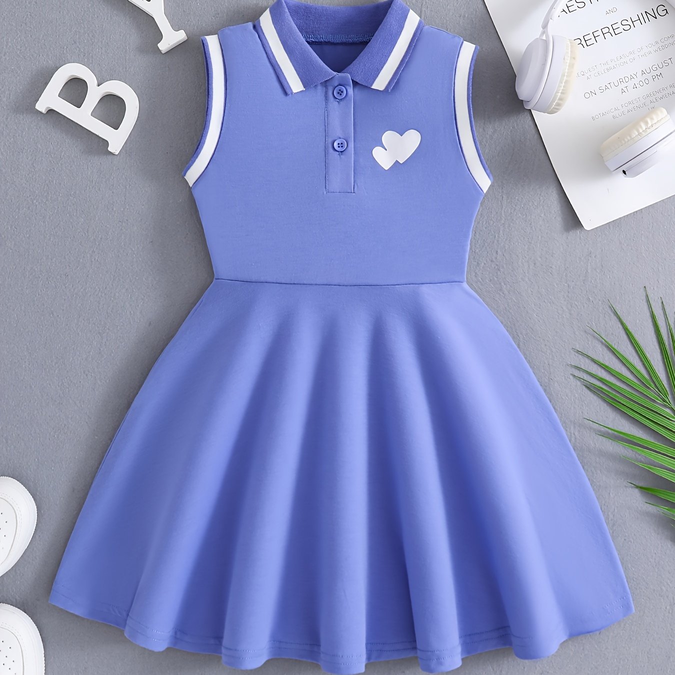 Qizlar uchun qizil tennis va sport libosi, nafas oladigan, teri so'radigan polyesterdan tayyorlangan, cho'ziluvchan va yengsiz dizayni bilan sport va tasodifiy kiyimlar uchun qora yozuvlar bilan sportiy nafislikni taqdim etadi.