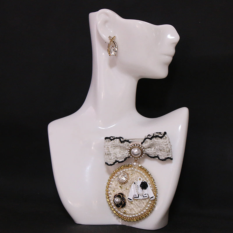 Ayollar modasi uchun sun'iy marjon bilan qora bowti brosh