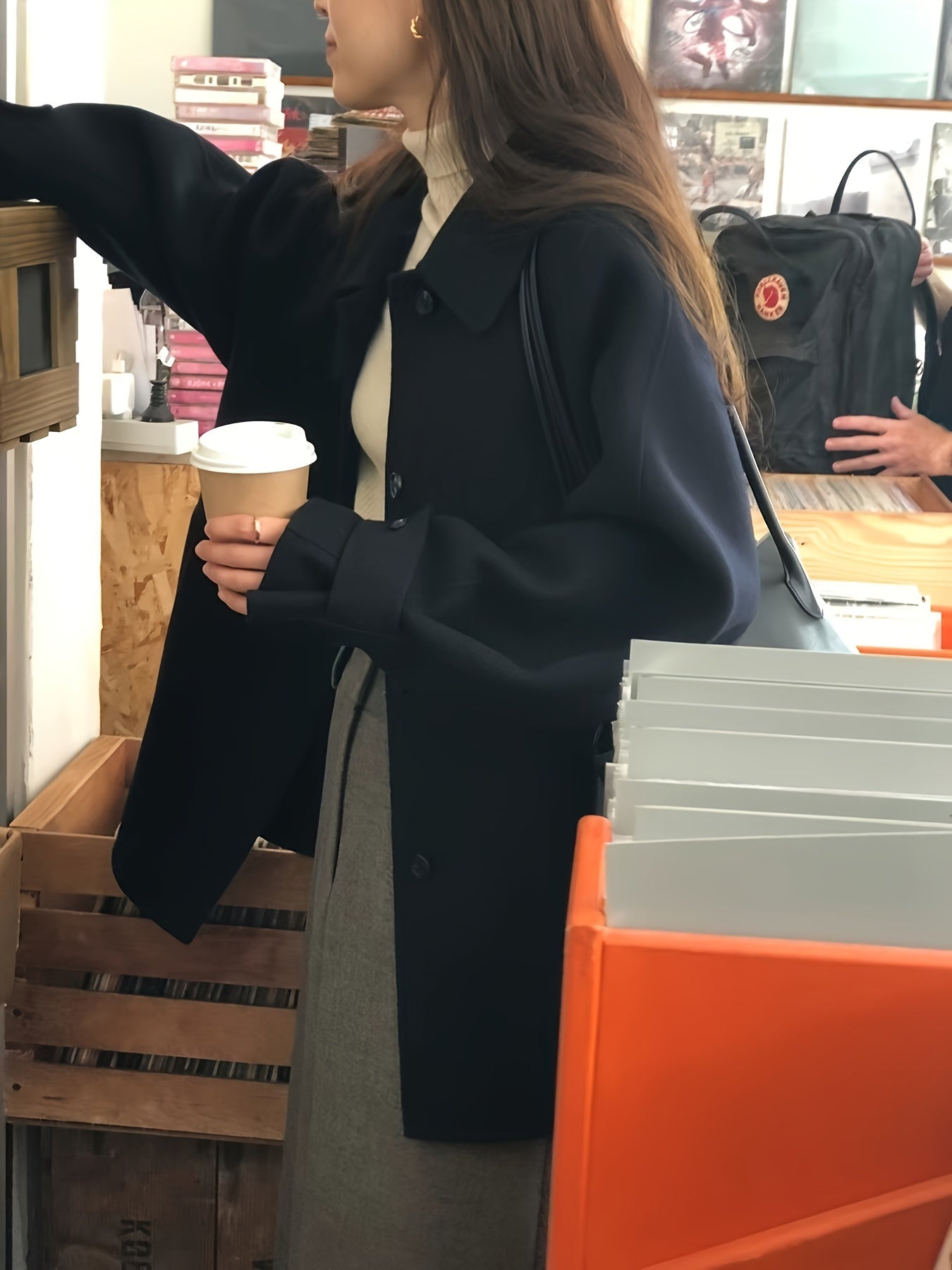 Zamonaviy kichik qora palto, retro yaka, bitta tugma, ko'rinmas cho'ntaklar - fransuz modasidan ilhomlangan tasodifiy, ammo nafis kuz/qish ko'rinishi uchun ideal.