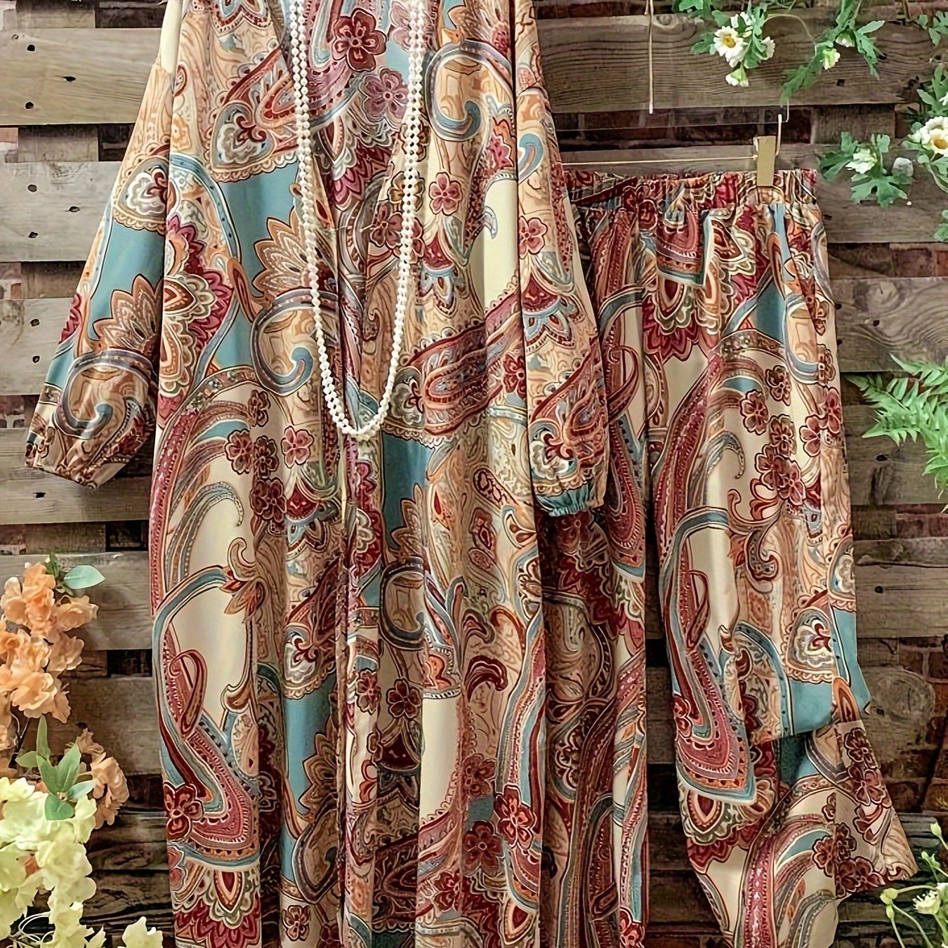 Katta o'lchamdagi ayollar uchun gullar naqshidagi ikki qismli to'plam ochiq old qismi va elastik belli shimlarni o'z ichiga oladi.