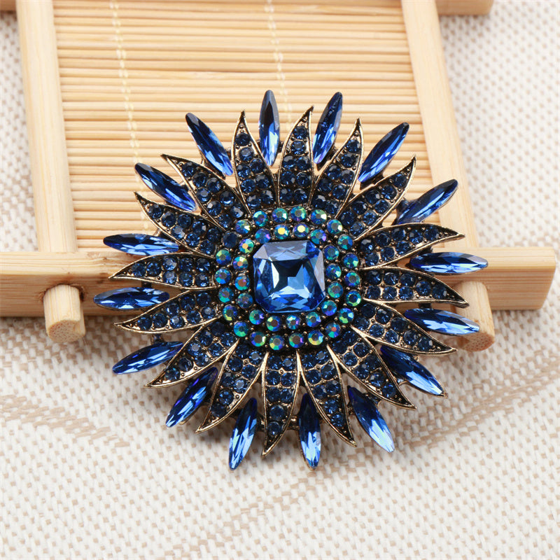 Bir nafis quyoshguli brosh, hashamatli kristal gullar bilan bezatilgan, o'ziga xos nishon, joziba va nafislikni tarqatadi. Do'stlar uchun mukammal aksessuar sovg'asi.