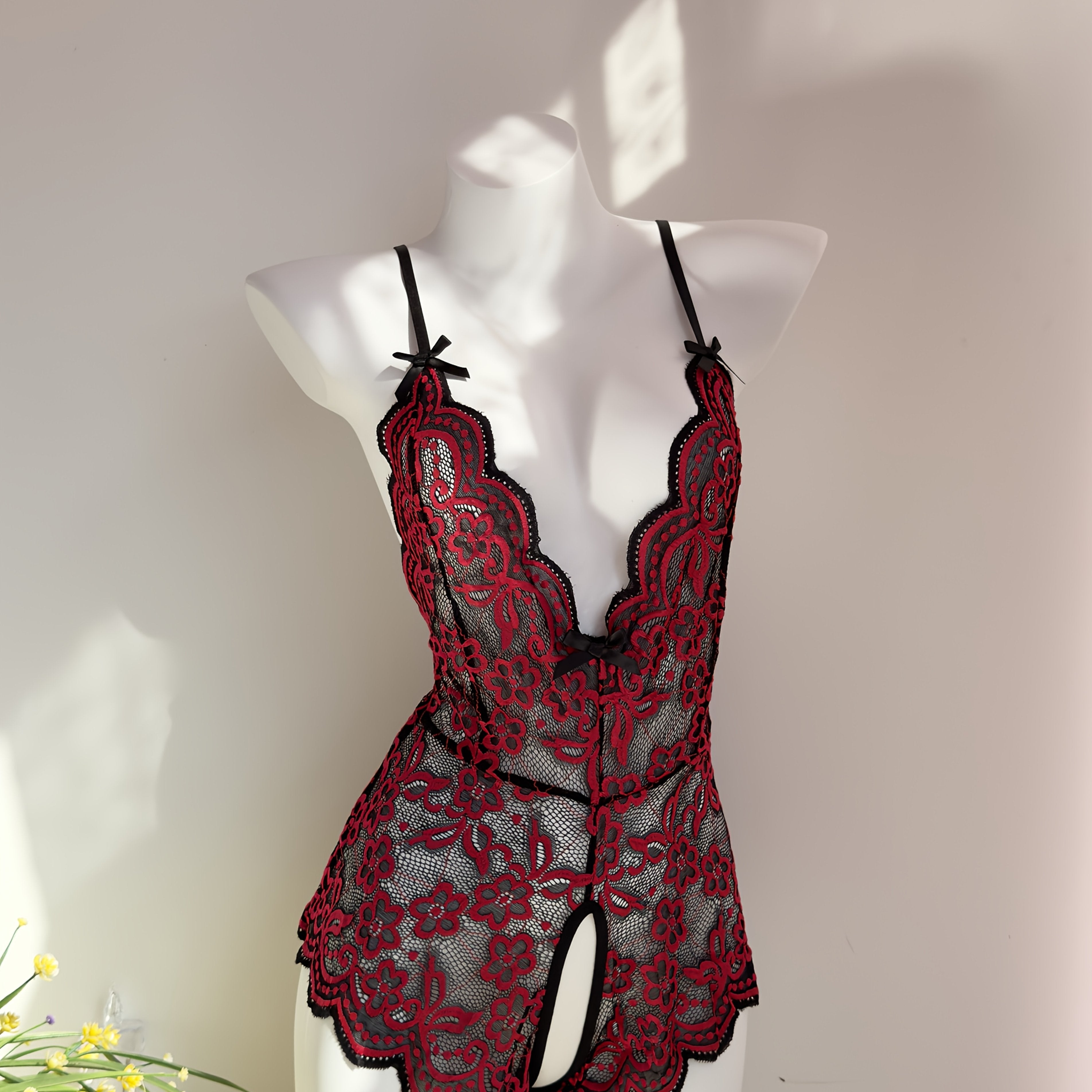 Jozibali dantel bodysuit, chuqur V-shakl, ochiq orqa va kesish tasma dizayni bilan.