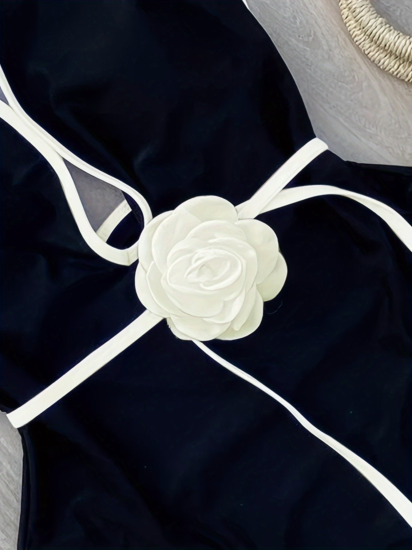 Bir parcha oq gullar bilan bezatilgan bog'ichli plyaj bikini.